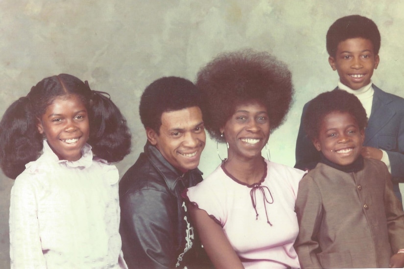 A man, a woman and three young children pose for a photo.