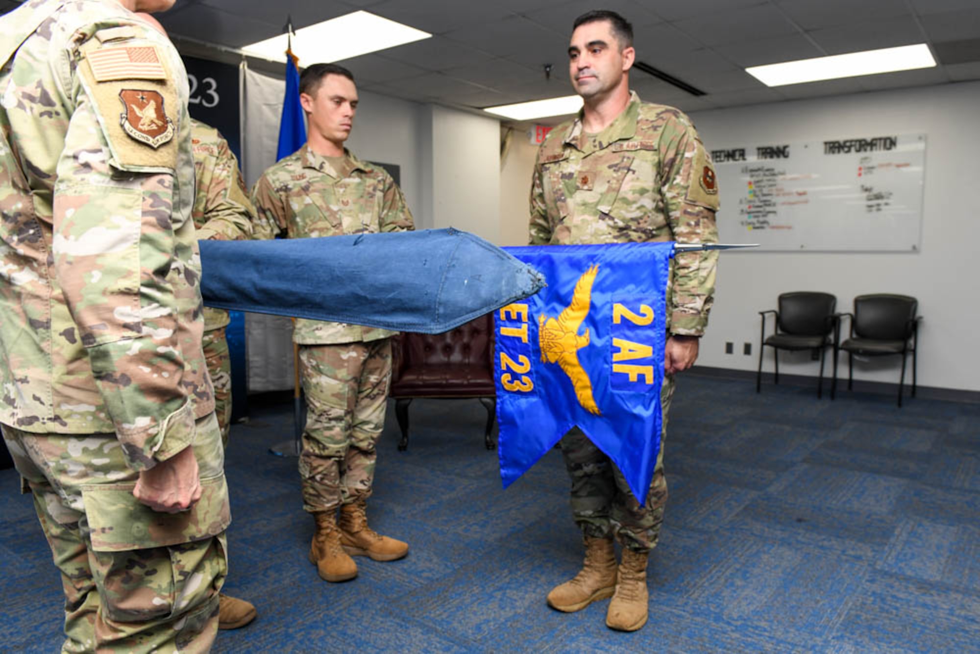U.S. Air Force Maj. Gen. Michele Edmondson, left, Second Air Force commander, and USAF Maj. Jesse Johnson, right, Detachment 23 commander, stand in formation as orders to reveal the new guidon are read during the Det. 23. Re-alignment ceremony.