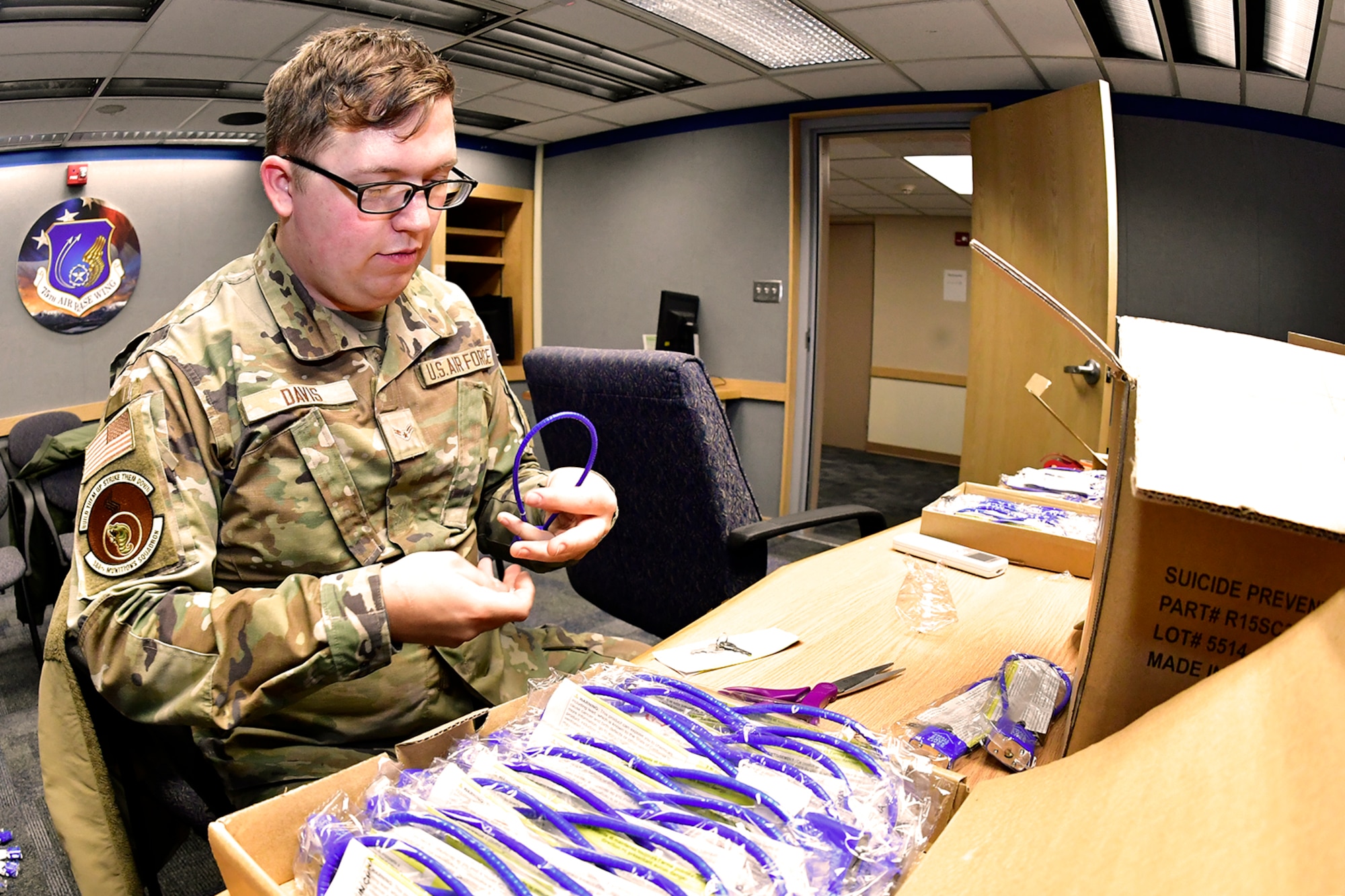 Airman 1st Class Josiah Davis, 338th Munitions Squadron, volunteers to prepare suicide prevention cable locks for distribution Feb. 7, 2023, at Hill Air Force Base, Utah. These locks were provided by the Headquarters Air Force Suicide Prevention Program and are known as a time-based prevention tool, designed to delay access to firearms and medicine, for those contemplating suicide during an emotionally charged moment. (U.S. Air Force photo by Todd Cromar)