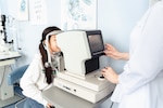 A girl looks into an eye test machine