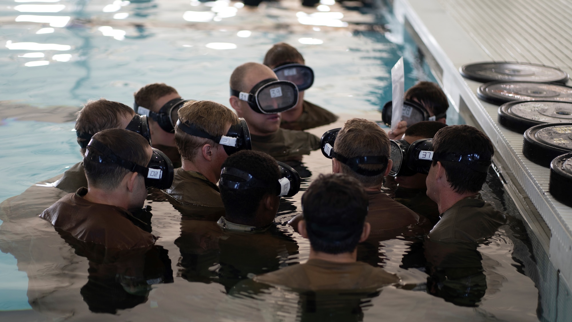 Special Warfare Training Wing trainees discuss a plan of action before a water confidence exercise.