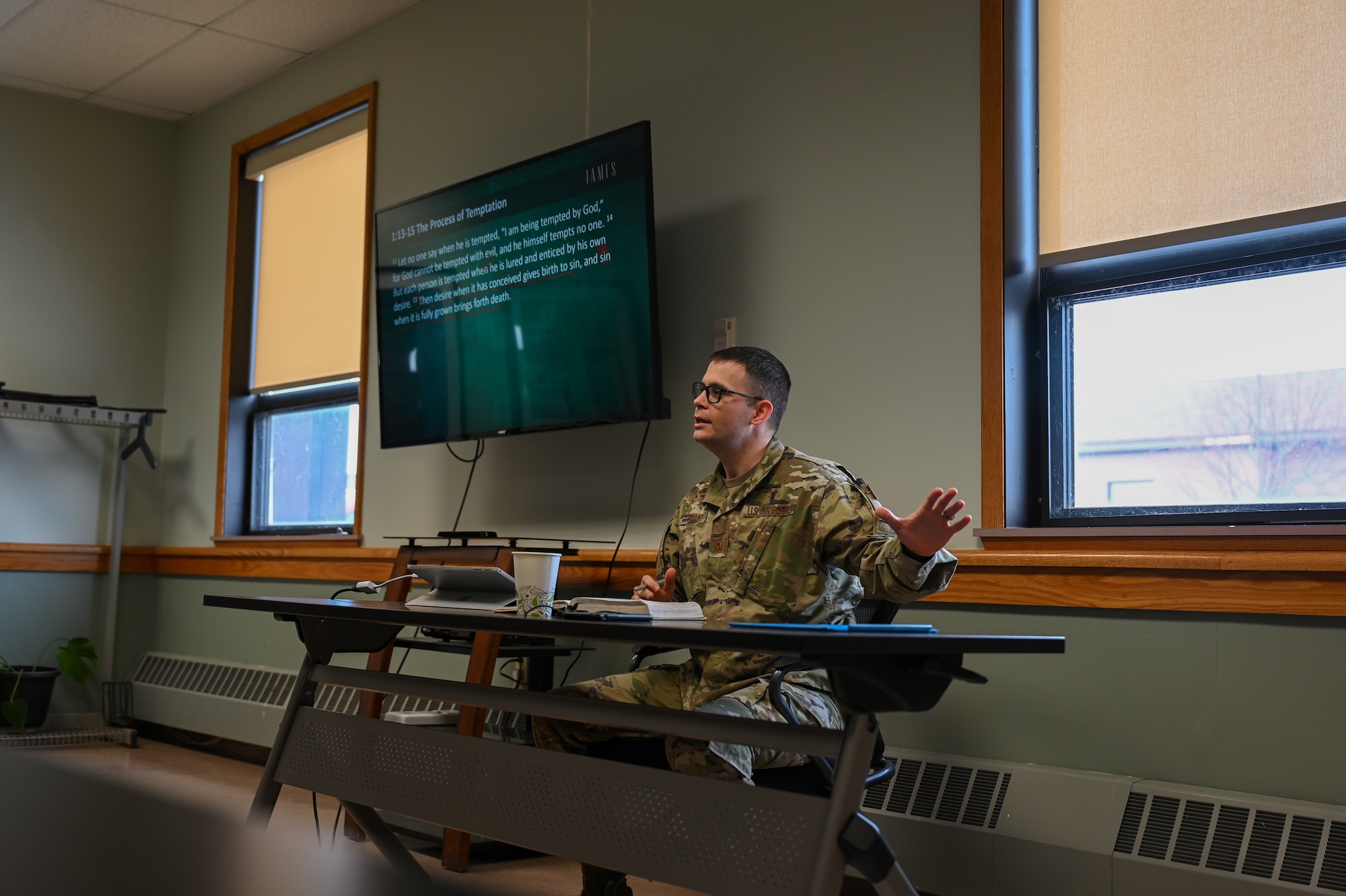 Air Force chaplain sitting at desk speaking to a group.