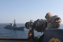 230214-N-JO162-1100 ARABIAN SEA (Feb. 14, 2023) Gunner’s Mate Seaman Nicholas Dickinson stands watch on the guided-missile destroyer USS Truxtun (DDG 103) as Pakistan Navy guided-missile frigate PNS Saif (F 253) sails alongside during exercise AMAN 23, in the Arabian Gulf, Feb 14, 2023. Truxtun is deployed to the U.S. 5th Fleet area of operations to help ensure maritime security and stability in the Middle East region.