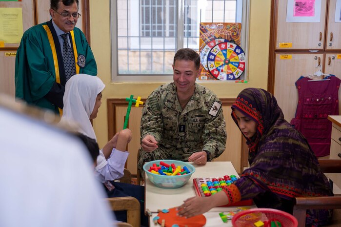 230215-N-EG592-1192 KARACHI, Pakistan (Feb. 15, 2023) Vice Adm. Brad Cooper, commander of U.S. Naval Forces Central Command (NAVCENT), U.S. 5th Fleet and Combined Maritime Forces, interacts with a child and her teacher at the Special Children School at Pakistan Naval Station Karsaz in Karachi, Feb. 15, 2023. NAVCENT personnel delivered physical therapy and mobility equipment to the school.