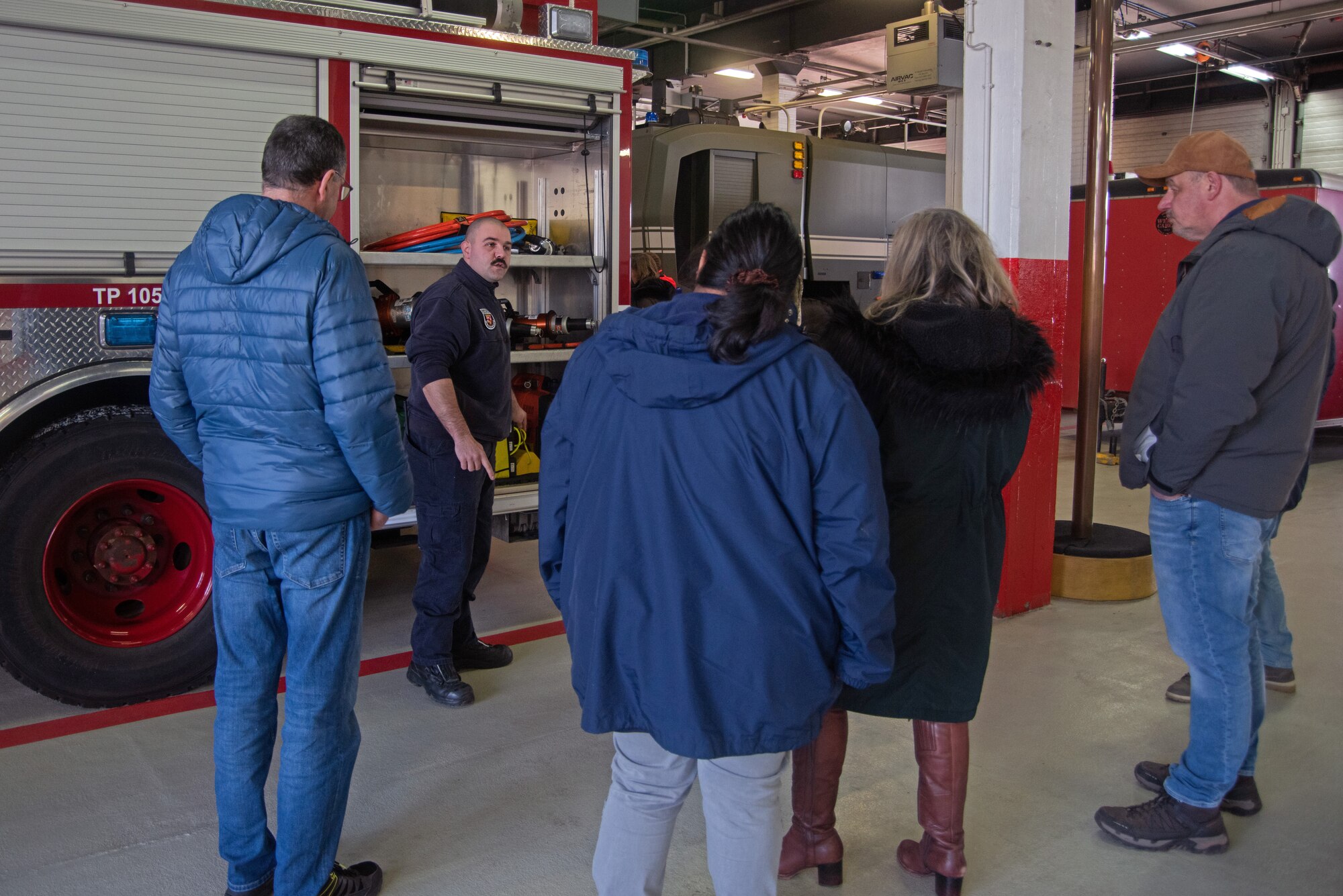 Civilian employees talk to a firefighter.