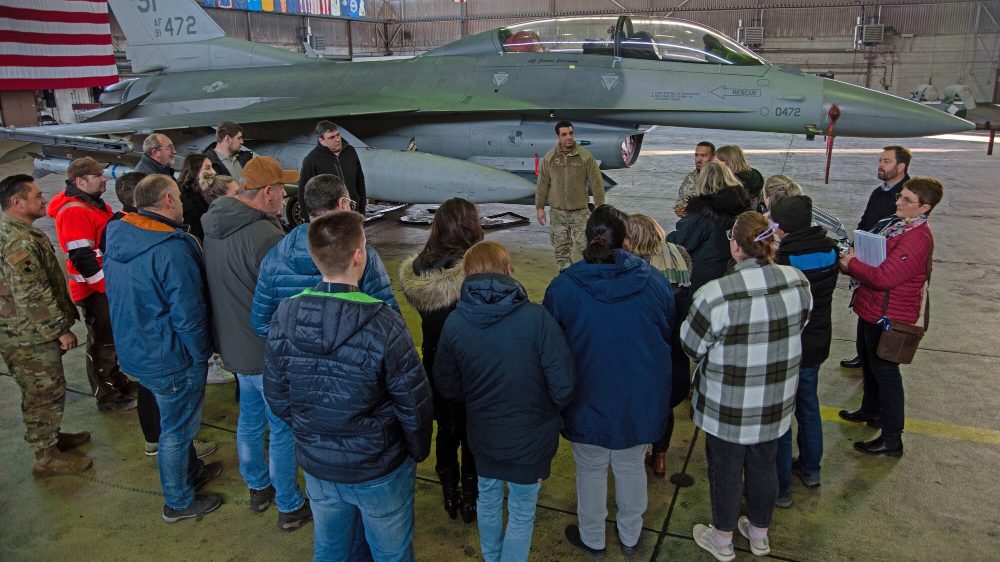 Civilian employees look at an F-16.