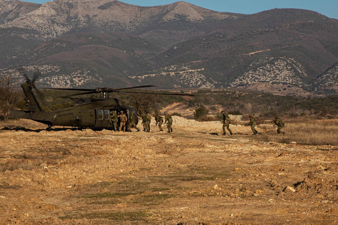 Soldiers run to board a helicopter as part of a training mission.