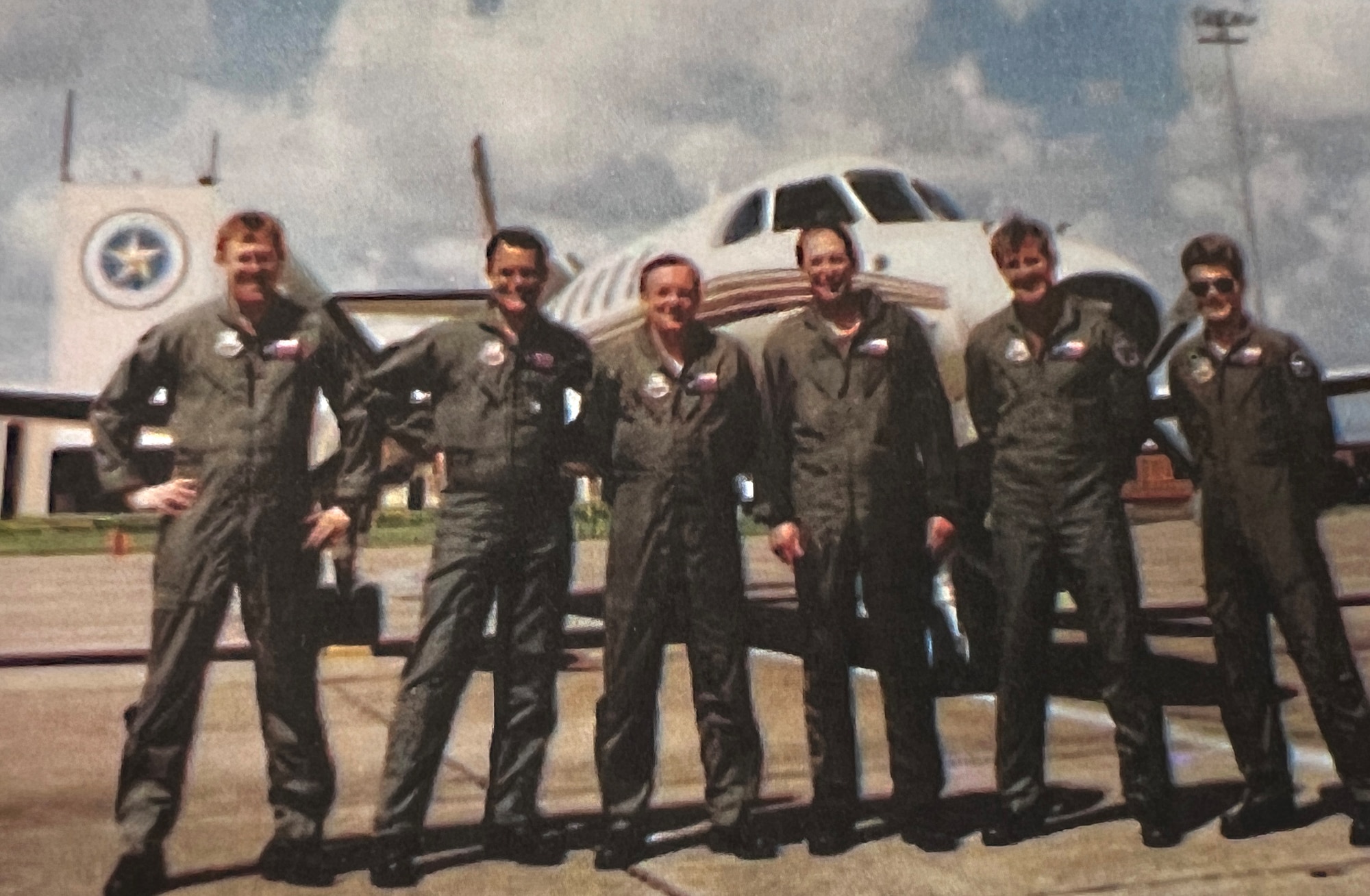 RC-26 crew members pose in front of their aircraft.
