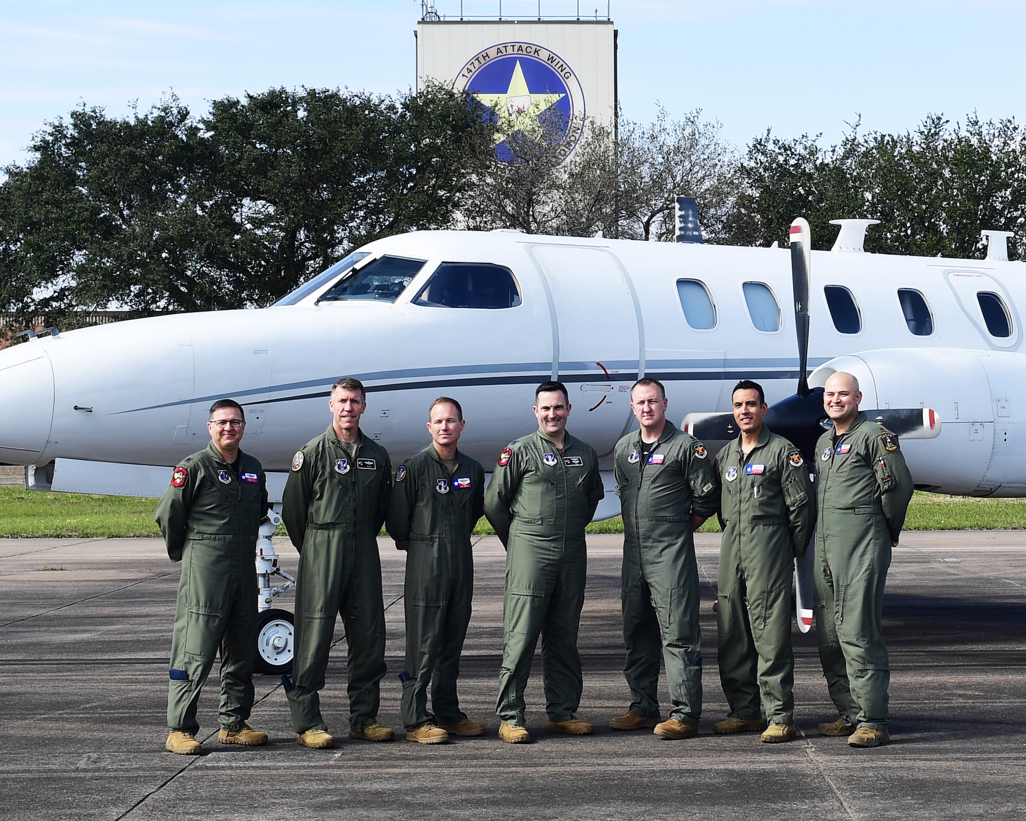 RC-26 crew members pose in front of their aircraft.