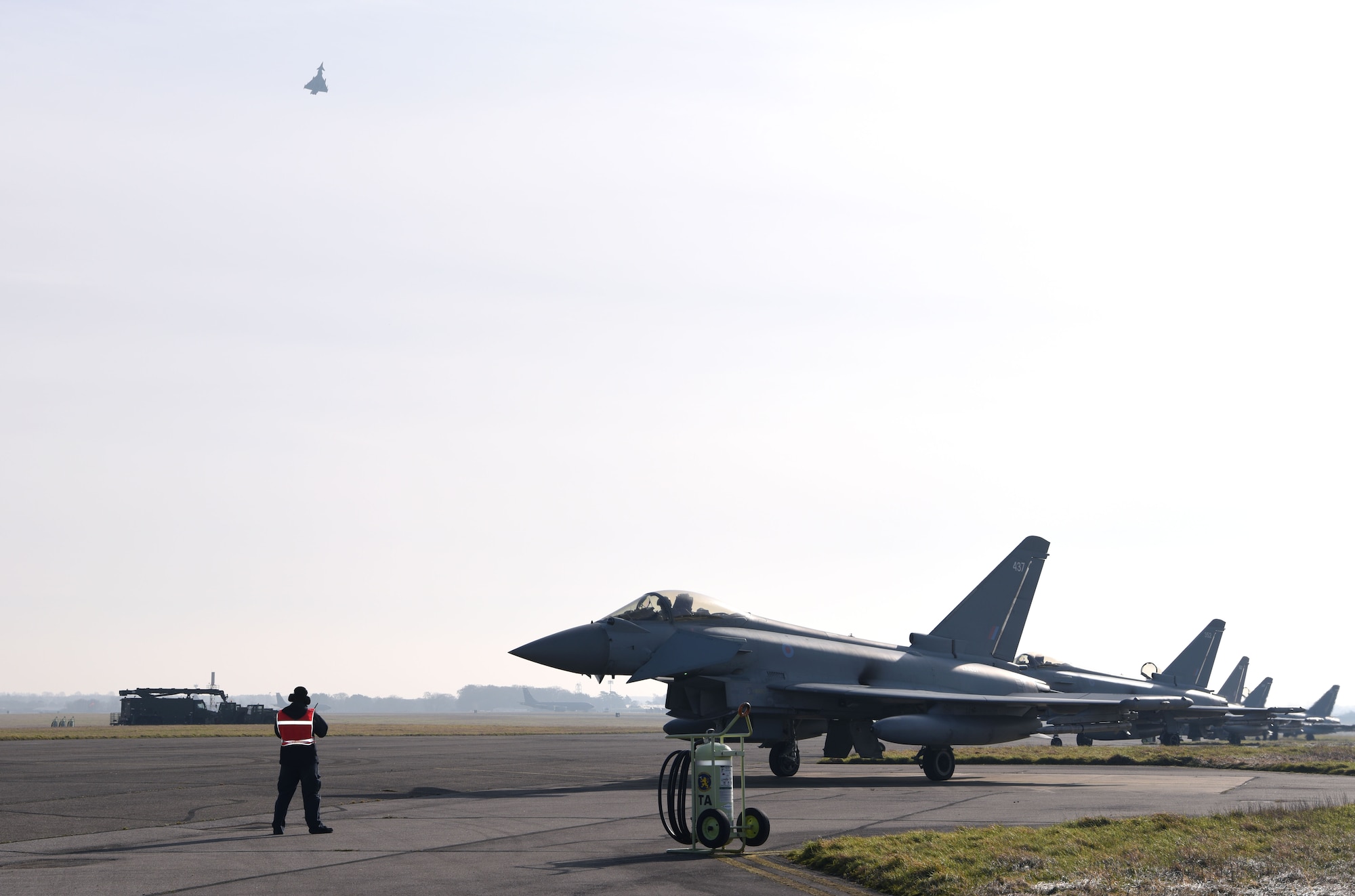 A Team Mildenhall member from transient alert prepares to marshal out Royal Air Force Eurofighter Typhoons at Royal Air Force Mildenhall, England, Feb. 15, 2023. The aircraft, from RAF Coningsby, England, diverted here due to bad weather. The Typhoon is a highly capable and extremely agile multi-role combat aircraft, and the pilot performs many essential functions through the aircraft’s hands on throttle and stick interface which – combined with an advanced cockpit and the helmet equipment assembly – renders the Typhoon superbly equipped for all aspects of air operations. (U.S. Air Force photo by Karen Abeyasekere)