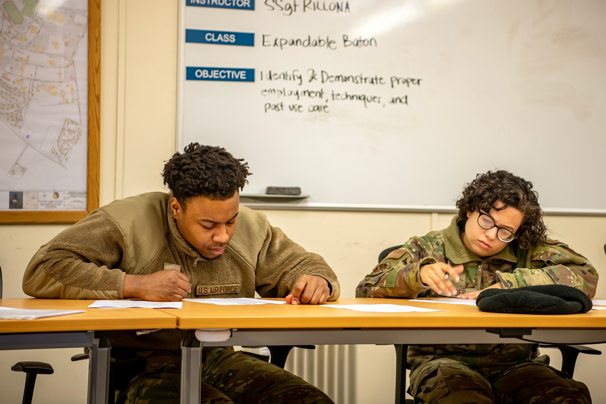 Airmen from the 423d Security Forces Squadron take a written test during a non-lethal combatives qualification course at RAF Alconbury, England, Feb. 7, 2023. The course provided Defenders with the skills and knowledge to properly detain a suspect using non-lethal combative methods. (U.S. Air Force photo by Staff Sgt. Eugene Oliver)