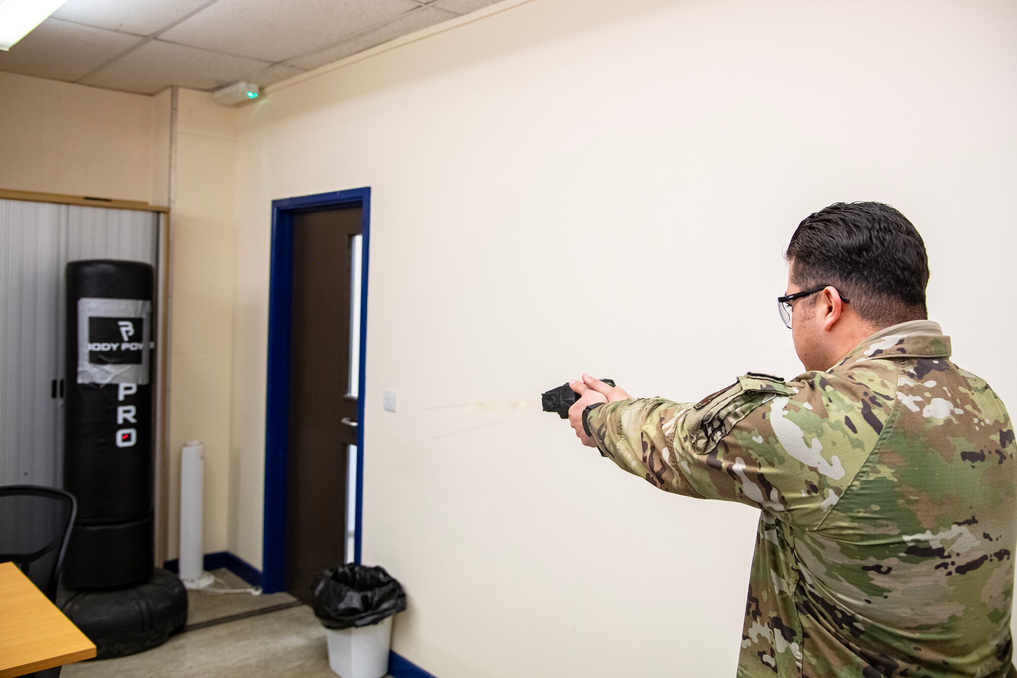 U.S. Air Force Staff Sgt. Andres Carbrera, 423d Security Forces Squadron flight sergeant, demonstrates proper Taser firing techniques during a non-lethal combatives qualification course at RAF Alconbury, England, Feb. 7, 2023. The course provided Defenders with the skills and knowledge to properly detain a suspect using non-lethal combative methods. (U.S. Air Force photo by Staff Sgt. Eugene Oliver)