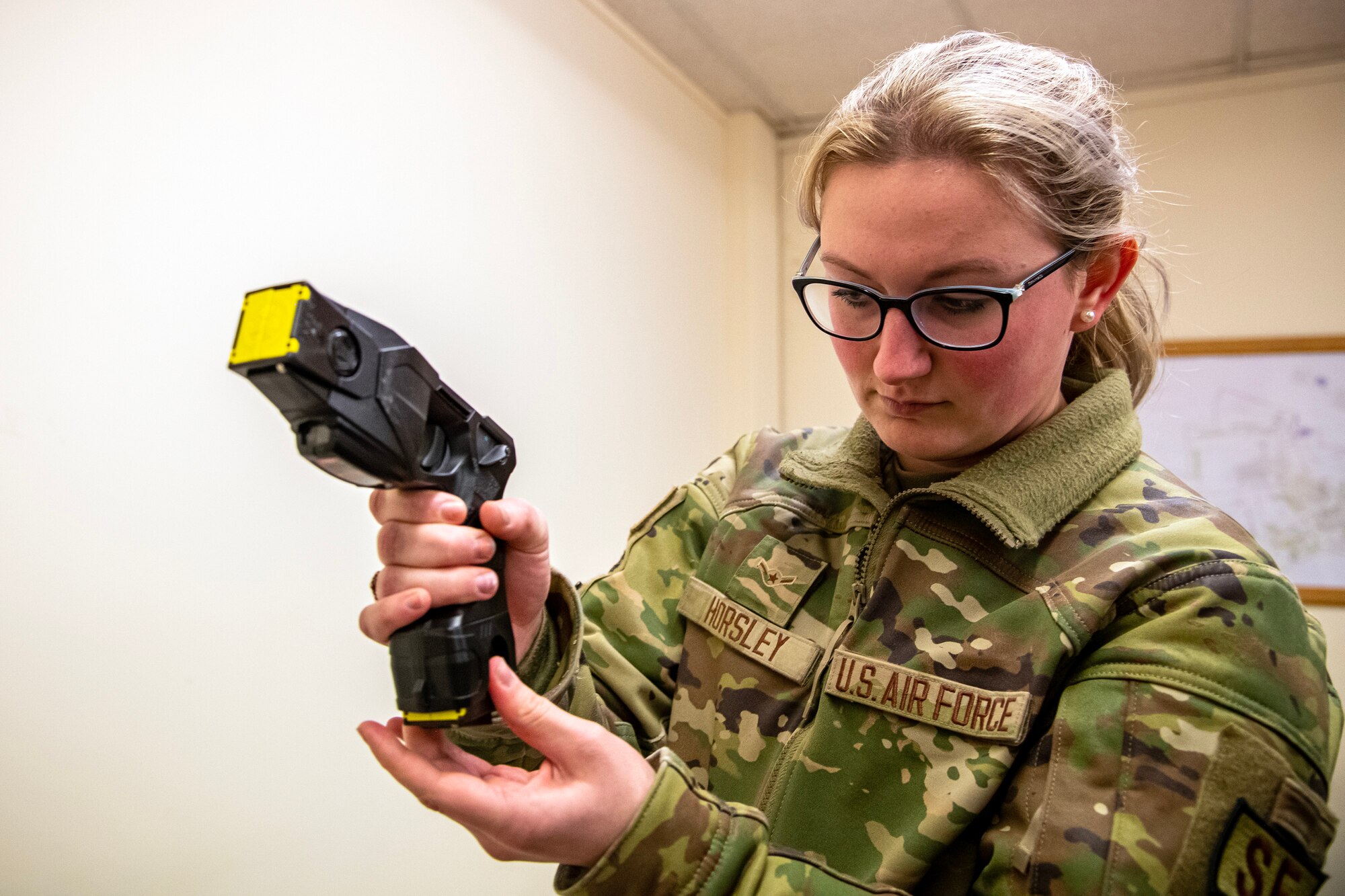 An Airman from the 423d Security Forces Squadron arms a Taser during a non-lethal combatives qualification course at RAF Alconbury, England, Feb. 7, 2023. The course provided Defenders with the skills and knowledge to properly detain a suspect using non-lethal combative methods. (U.S. Air Force photo by Staff Sgt. Eugene Oliver)