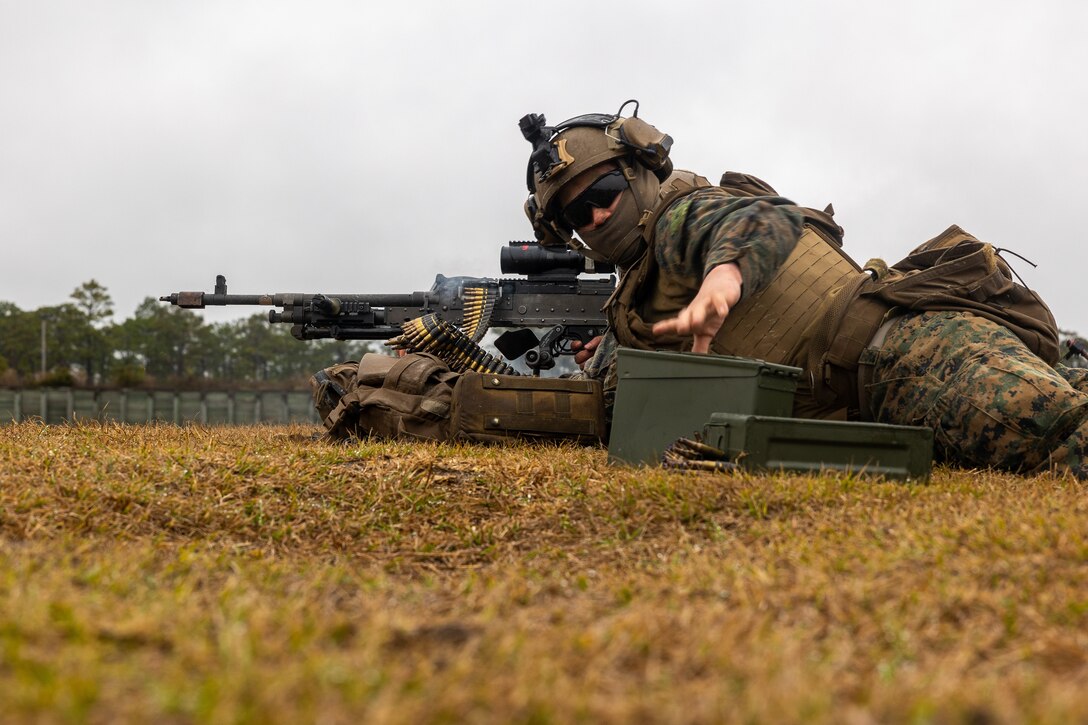 U.S. Marine Corps Lance Cpl. Sevastian Cruzvasquez, a machine gunner with the Battalion Landing Team 1/6, 26th Marine Expeditionary Unit, prepares to grab a machine gun ammunition box during a live-fire event part of a raid on Marine Corps Base Camp Lejeune, North Carolina, Feb. 2, 2023. The MEU Exercise II (MEUEX) culminated with an opportunity to train to the initial stages of an amphibious assault aimed to seize key maritime terrain coupled with the full debarkation of the MEU Marine Air-Ground Task Force. (U.S. Marine Corps photo by Cpl. Nayelly Nieves-Nieves)