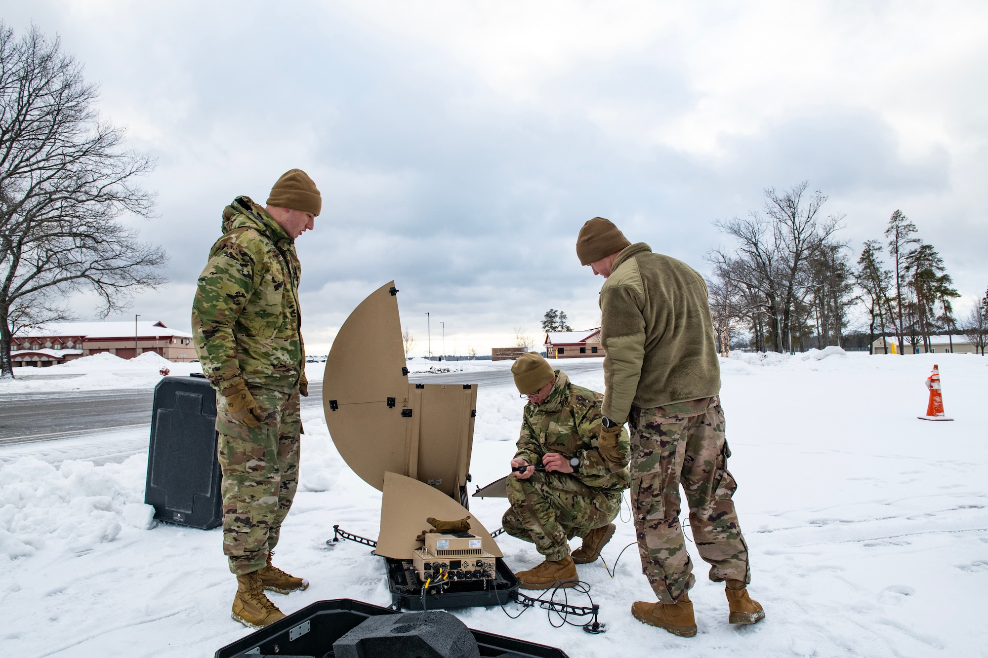 U.S. Air Force Airmen from the 290th Joint Communications Support Squadron set up satellite terminals during an exercise Feb. 10, 2023, at Alpena Combat Readiness Training Center, Michigan. The exercise tested their ability to establish communication in extreme cold. (This photo has been altered for security purposes by blurring sensitive information.)