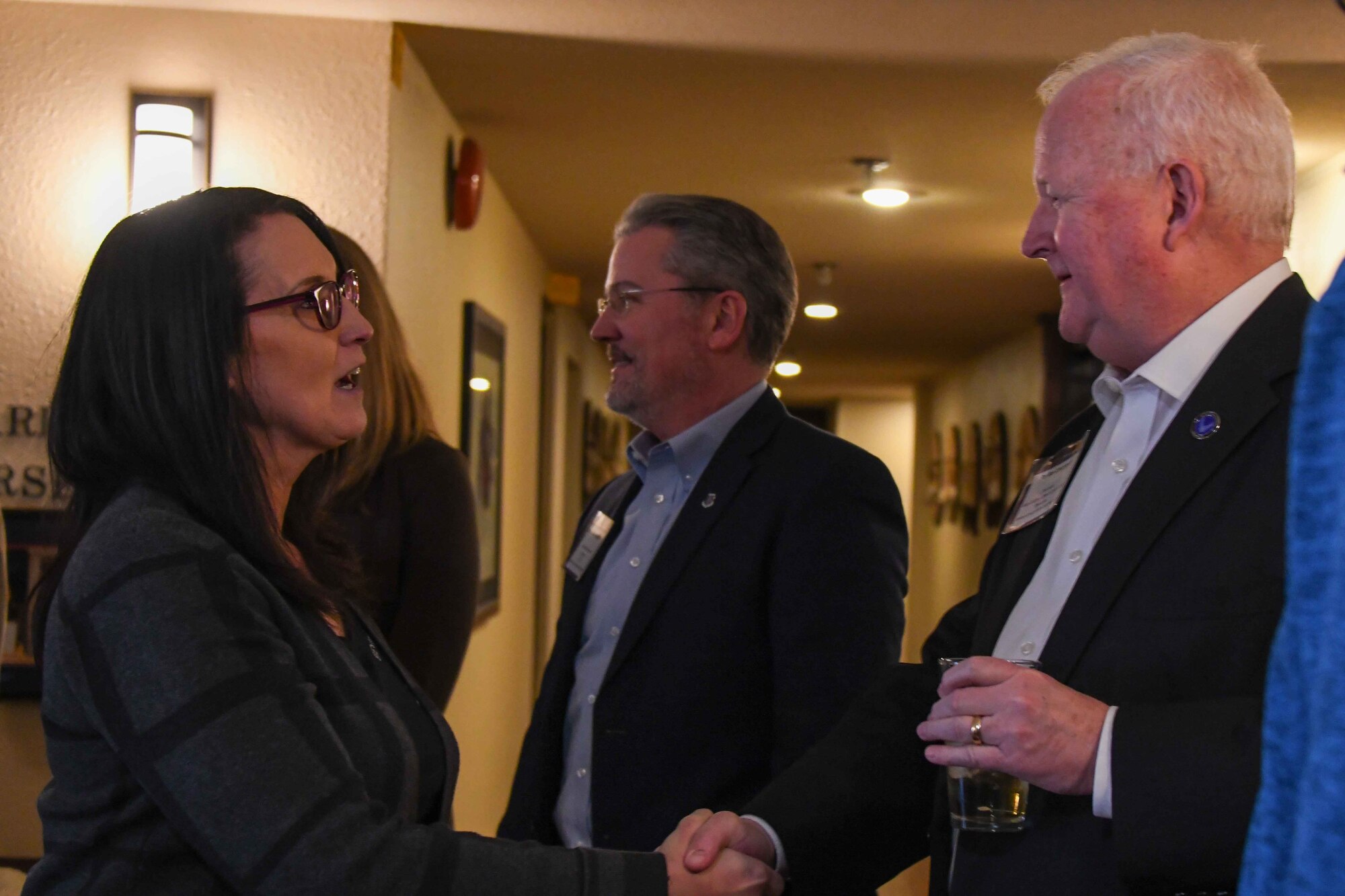 Dr. Joe Leverrett, chairman of the Altus Military Affairs committee, shakes hands with Mary Quantrell, former 62nd Aerial Port Squadron honorary commander at Altus Air Force Base, Oklahoma, Feb. 9, 2023. The 62nd Airlift Wing civic leaders met with the Altus Military Affairs Committee at Club Altus to exchange ideas and network. (U.S. Air Force photo by Airman 1stClass Kari Degraffenreed)