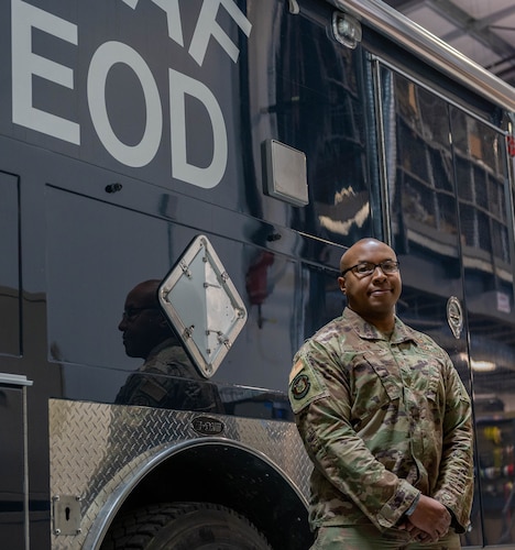 Airman standing next to a truck
