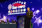 General Daniel Hokanson stands behind a podium while speaking to the audience at the 37th annual Black Engineer of the Year awards ceremony.