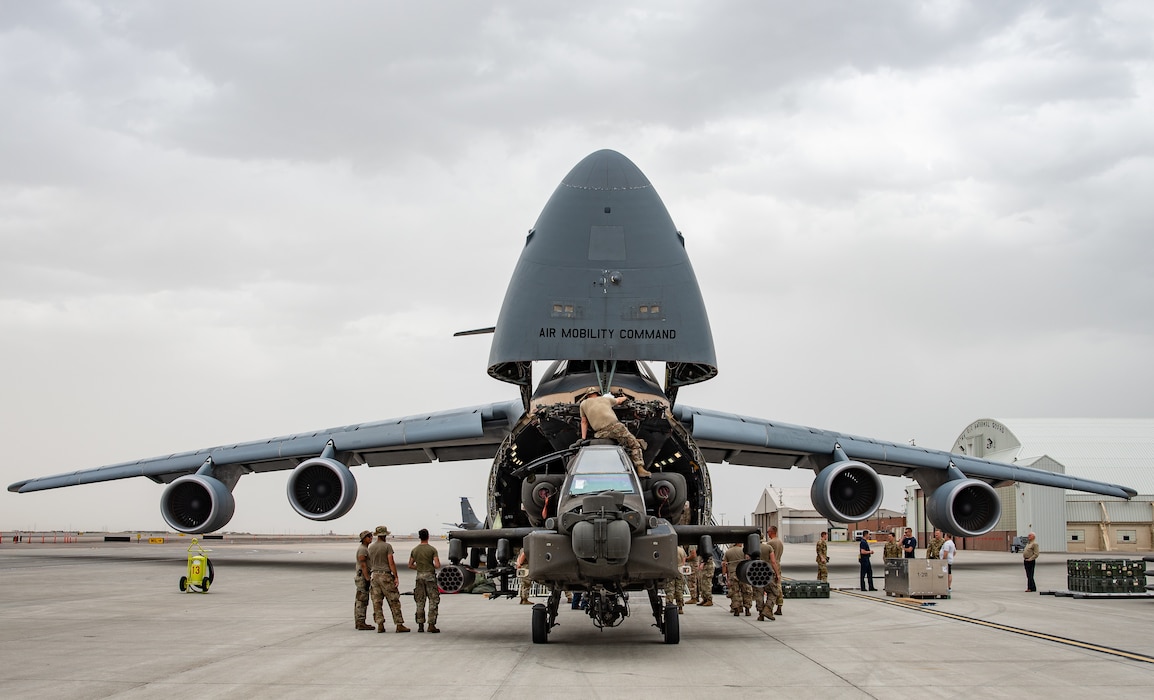 U.S. Air Force airmen load Apache helicopter into a C-5 aircraft