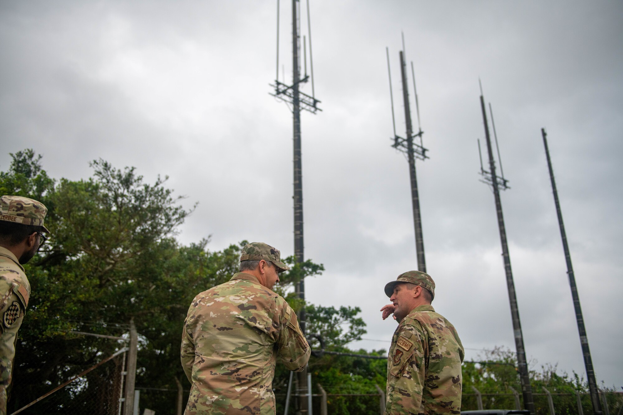 Two Airmen speak in front of towers.