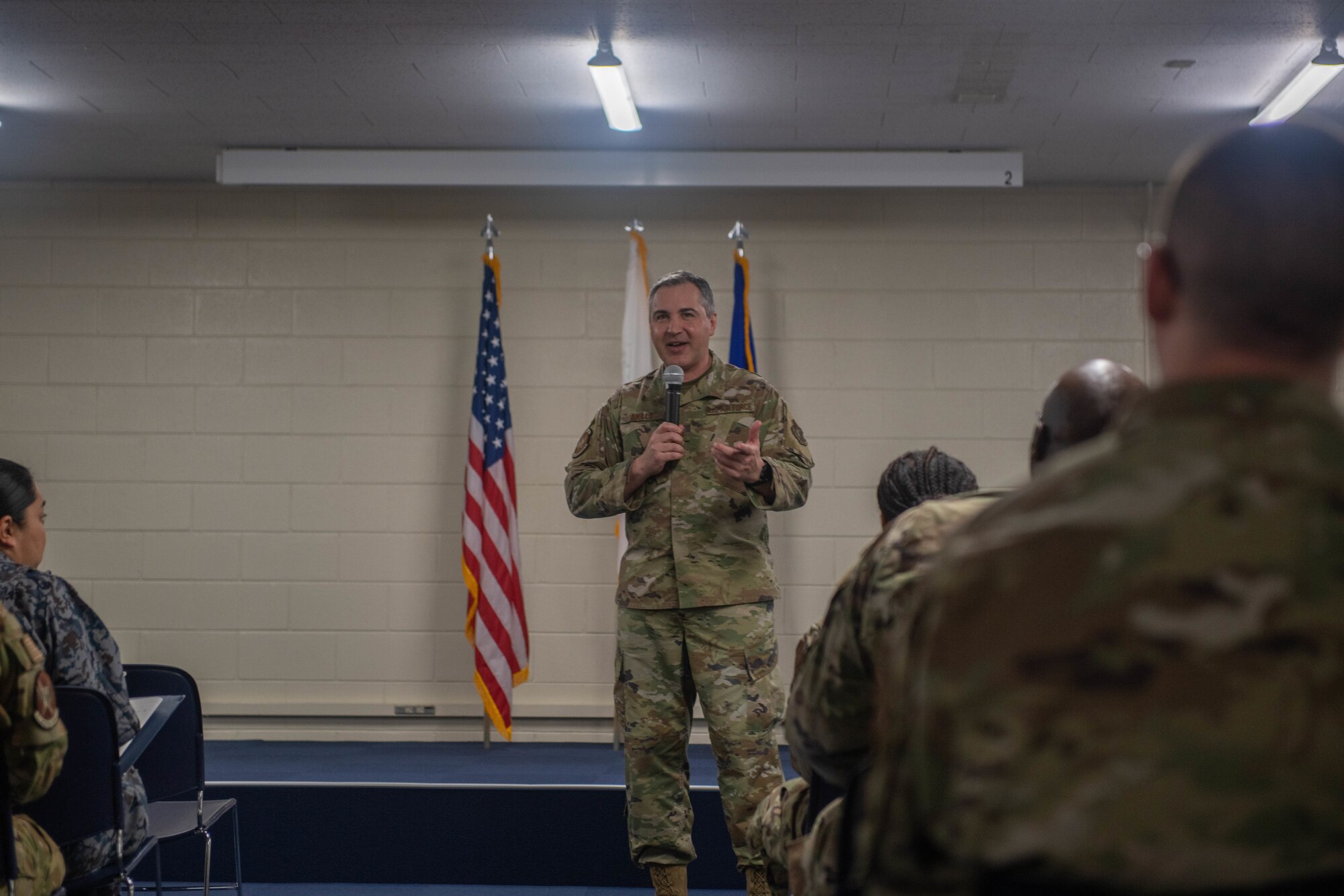 CMSgt speaks in front of flags.