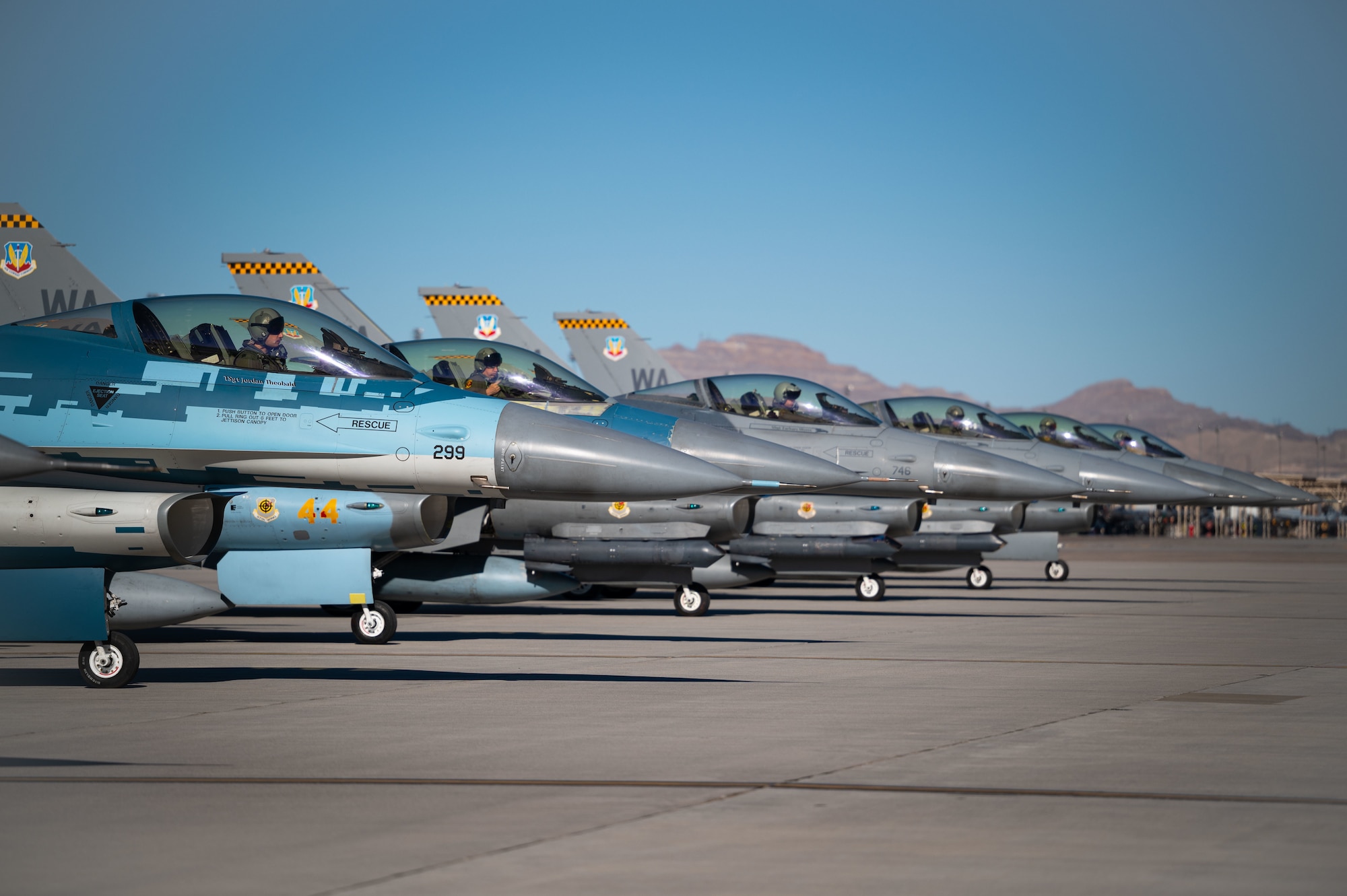 F-16C Fighting Falcons assigned to the 64th Aggressor Squadron at Nellis Air Force Base, Nevada, await take-off during Red Flag 23-1, Jan. 23, 2023. Red Flag provides participants the opportunity to plan and employ together in a contested, degraded and operationally limited environment. (U.S. Air Force photo by Senior Airman Megan Estrada)