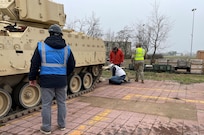 Employees and contractors from Army Field Support Battalion-Mannheim’s Coleman Army Prepositioned Stocks-2 worksite verify information on an M2A2 Bradley infantry fighting vehicle sent to Europe from the U.S. to support current operations in Europe. Coleman’s workforce plus supporting logistical partners are conducting full technical inspections on the Bradleys to ensure they are fully mission capable. If repairs are needed, the combined team at Coleman is performing the work at the APS-2 site before onward movement. (Photo by Jason Todd)