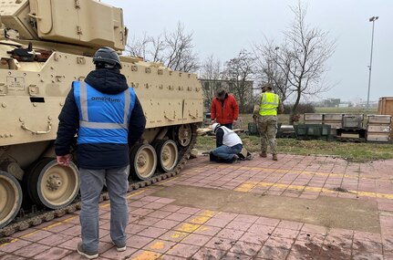 Employees and contractors from Army Field Support Battalion-Mannheim’s Coleman Army Prepositioned Stocks-2 worksite verify information on an M2A2 Bradley infantry fighting vehicle sent to Europe from the U.S. to support current operations in Europe. Coleman’s workforce plus supporting logistical partners are conducting full technical inspections on the Bradleys to ensure they are fully mission capable. If repairs are needed, the combined team at Coleman is performing the work at the APS-2 site before onward movement. (Photo by Jason Todd)