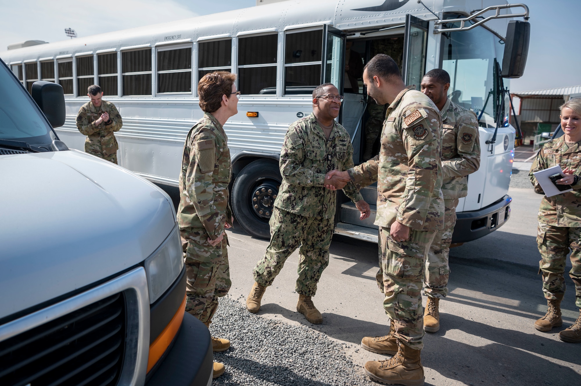 U.S. Navy Fleet Master Chief Donald O. Myrick, U.S. Transportation Command senior enlisted leader, shakes hands with U.S. Air Force Staff Sgt. Marino Marte, an 8th Expeditionary Air Mobility Squadron C-5 Galaxy hydraulics craftsman at Cargo City, Kuwait, Feb. 10, 2023.