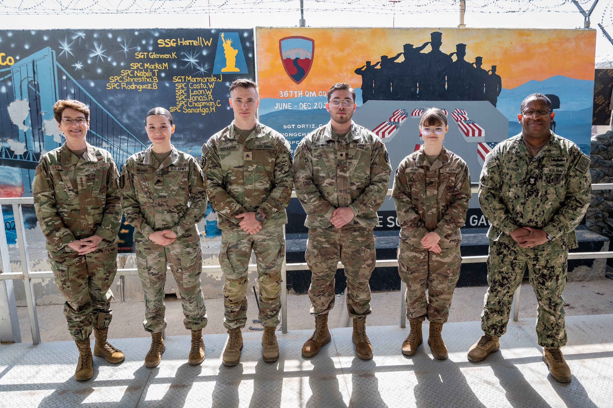 U.S. Army Soldiers pose for a photo with U.S. Air Force Gen. Jacqueline D. Van Ovost, U.S. Transportation Command commander, and U.S. Navy Fleet Master Chief Donald O. Myrick, USTRANSCOM senior enlisted leader, during their tour at Cargo City, Kuwait, Feb. 10, 2023.