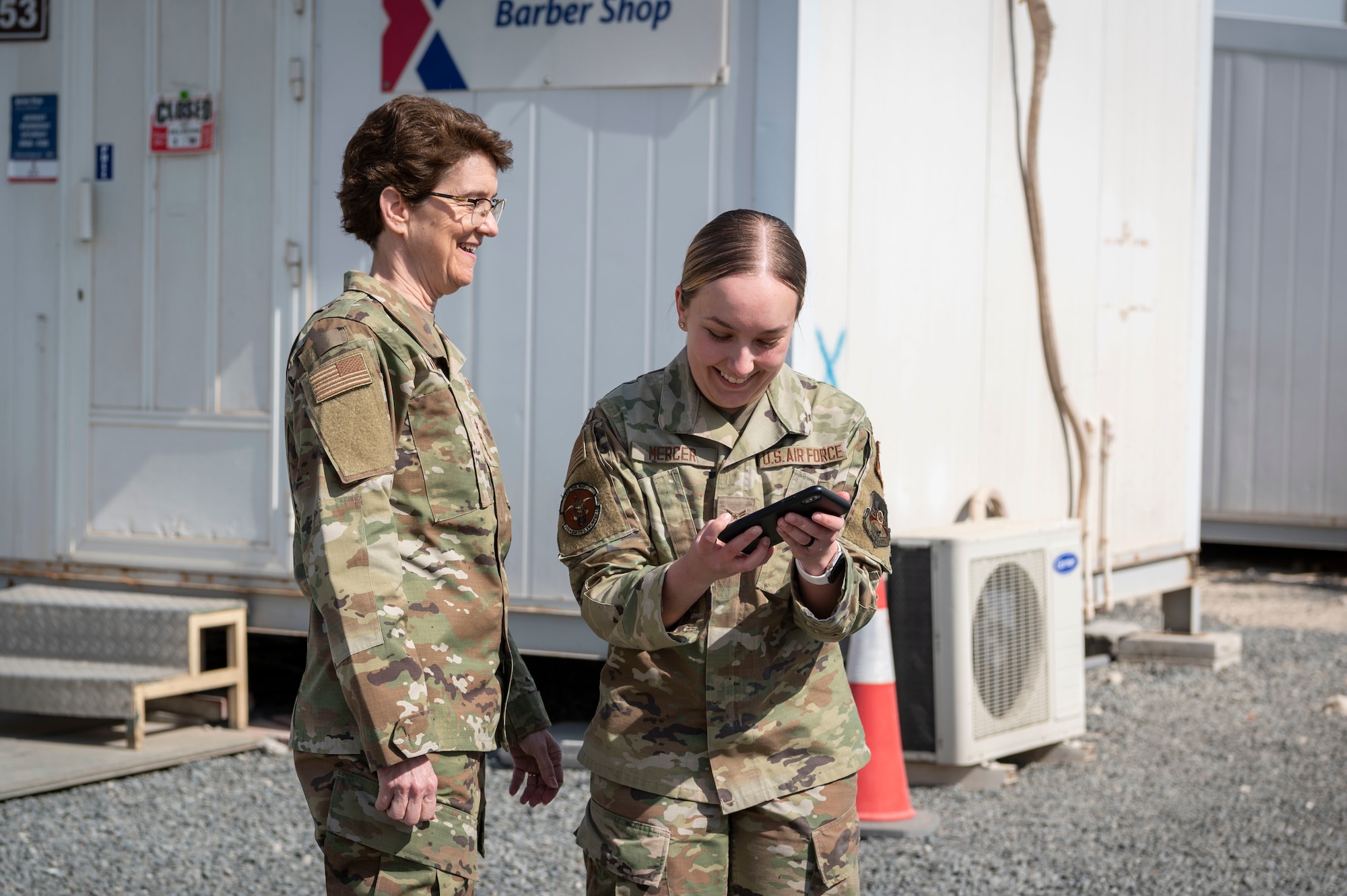U.S. Air Force Gen. Jacqueline D. Van Ovost, U.S. Transportation Command commander, and U.S. Air Force Airman 1st Class Paige Mercer, 386th Expeditionary Civil Engineer Squadron operations manager, prepare to take a photo together at Cargo City, Kuwait, Feb. 10, 2023.