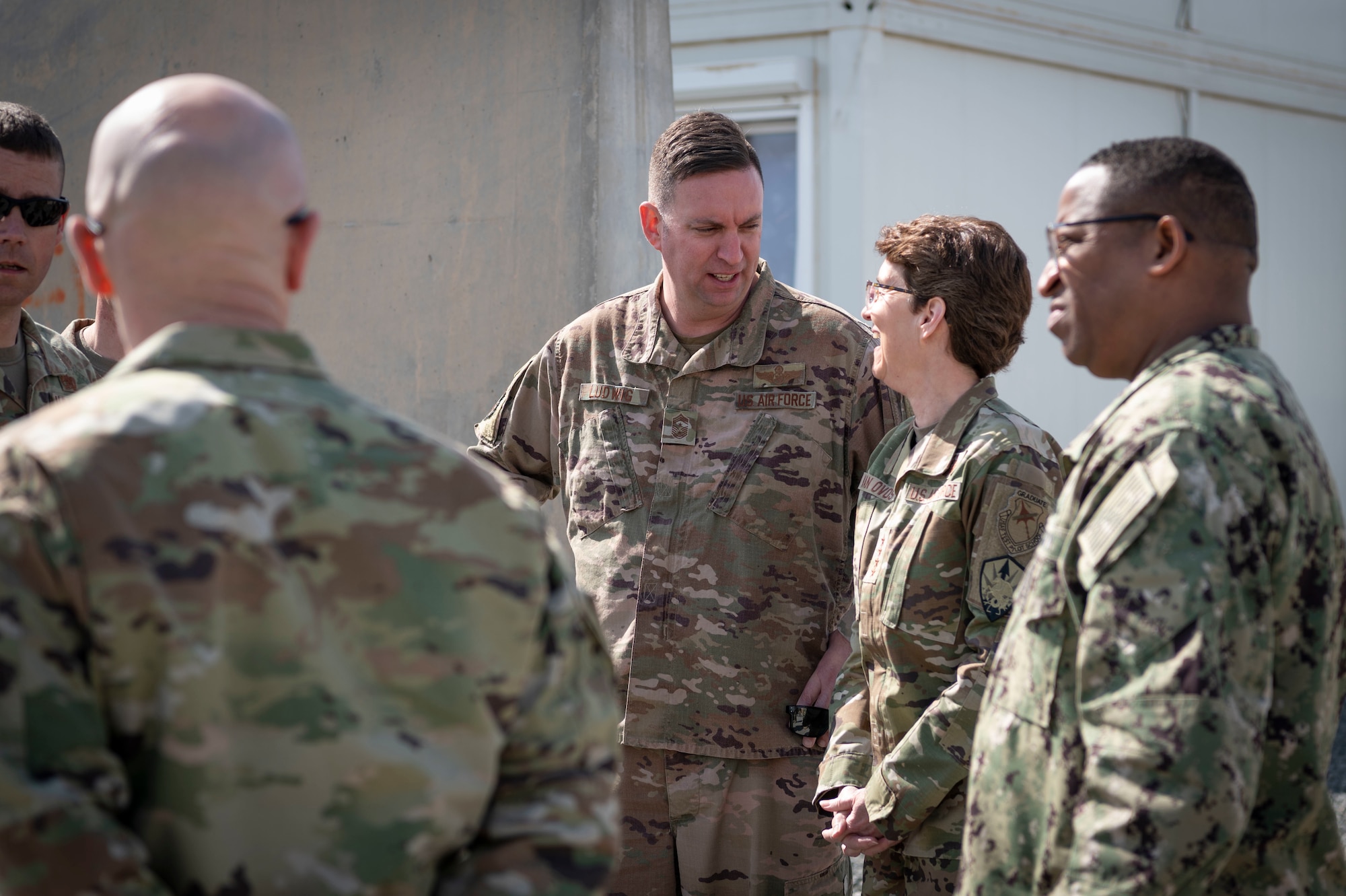 U.S. Air Force Chief Master Sgt. Louis Ludwig, 386th Air Expeditionary Wing command chief, talks to U.S. Air Force Gen. Jacqueline D. Van Ovost, U.S. Transportation Command commander, at Cargo City, Kuwait, Feb. 10, 2023.