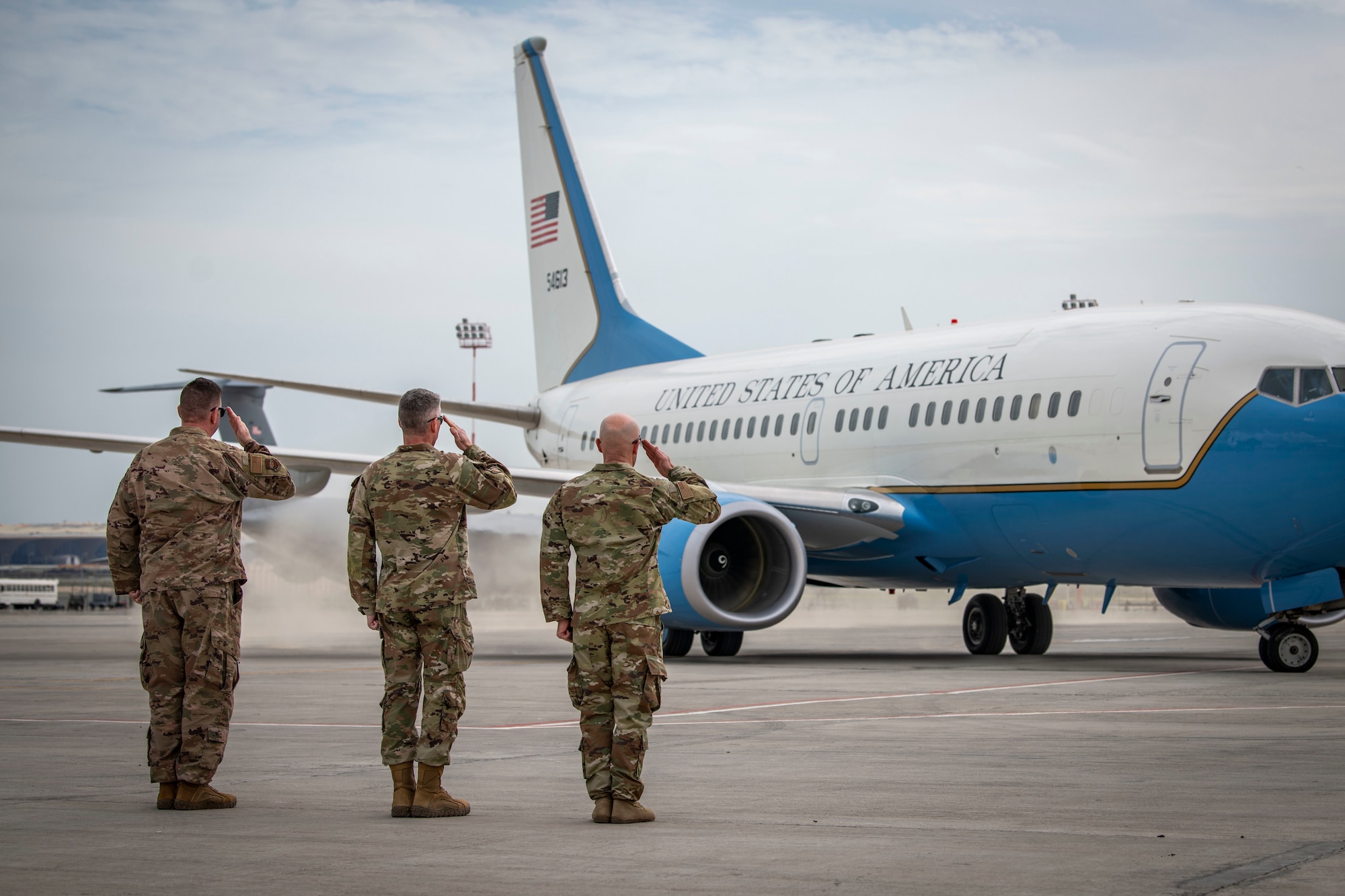 U.S. Air Force senior leaders from Ali Al Salem Air Base salute U.S. Air Force Gen. Jacqueline D. Van Ovost, U.S. Transportation Command commander, and U.S. Navy Fleet Master Chief Donald O. Myrick, USTRANSCOM senior enlisted leader, as they leave Cargo City, Kuwait, Feb. 10, 2023.