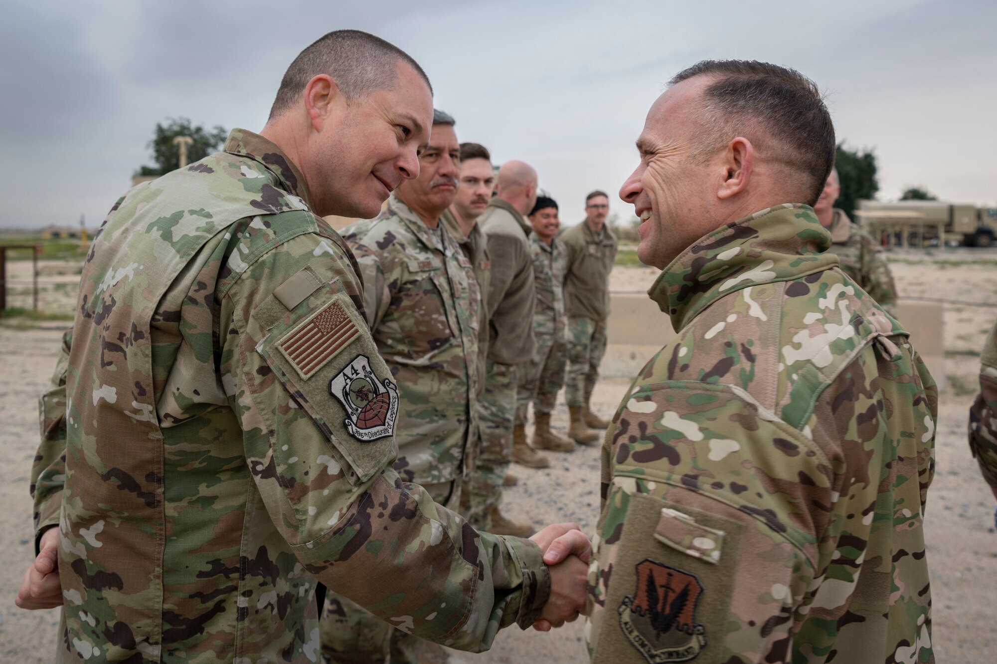 U.S. Air Force Command Chief Master Sgt. John Storms, right, Air Combat Command, greets Chief Master Sgt. Michael Reid, 386th Air Expeditionary Wing A4 senior enlisted leader, during a tour at Ali Al Salem Air Base, Kuwait, Feb. 15, 2023.