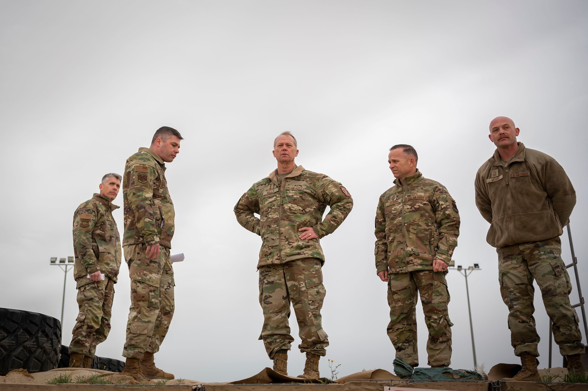 U.S. Air Force Gen. Mark Kelly, commander of Air Combat Command and Command Chief Master Sgt. John Storms, ACC, along with Col. George Buch, left, 386th Air Expeditionary Wing commander, and 386th Expeditionary Logistics Readiness Squadron leadership, look out over the fuel farm during a tour at Ali Al Salem Air Base, Kuwait, Feb. 15, 2023.