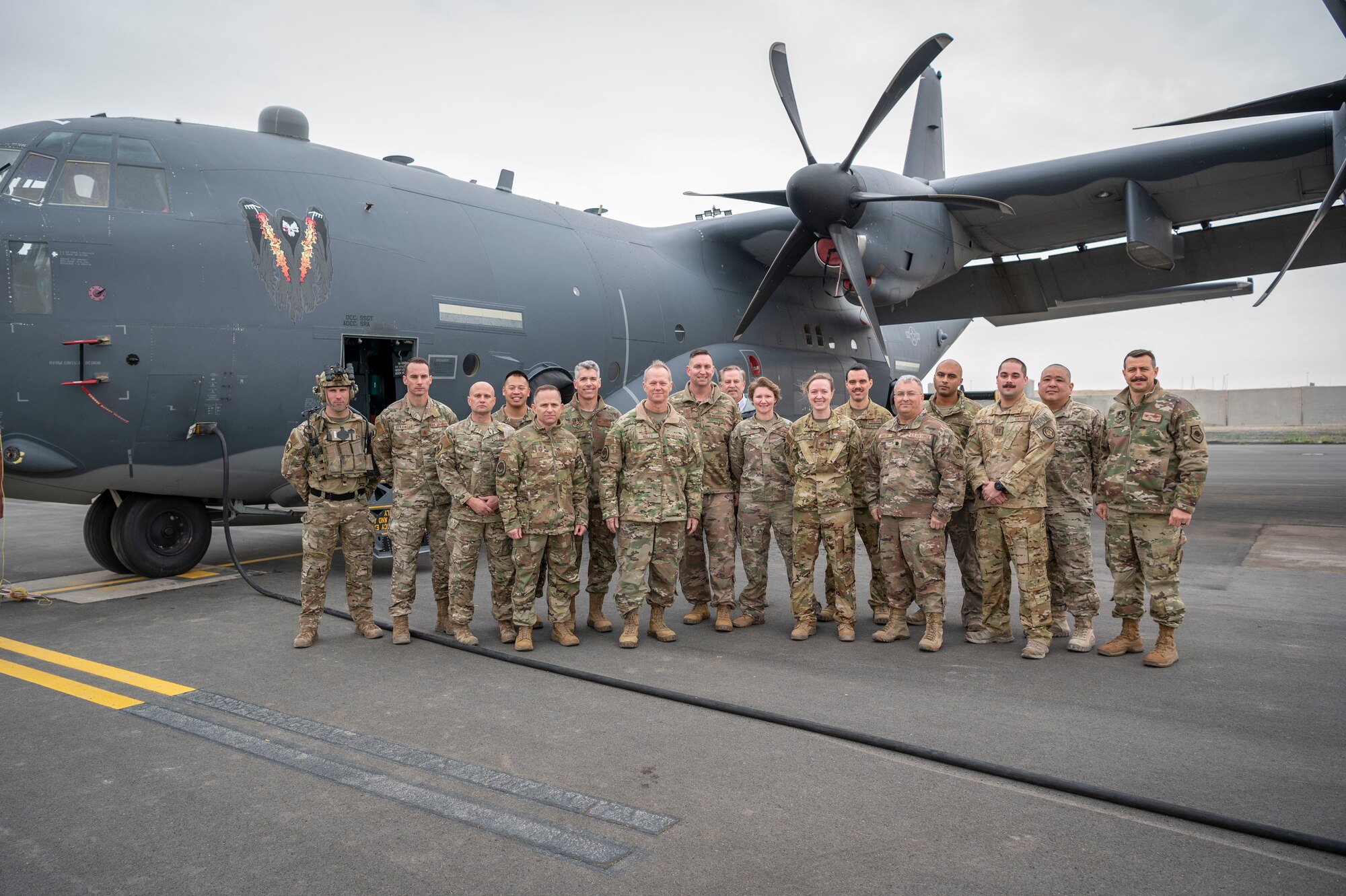 U.S. Air Force Gen. Mark Kelly, commander of Air Combat Command and Command Chief Master Sgt. John Storms, ACC, pose for a photo with Airmen in front of an AC-130J Ghostrider gunship during a tour at Ali Al Salem Air Base, Kuwait, Feb. 15, 2023.