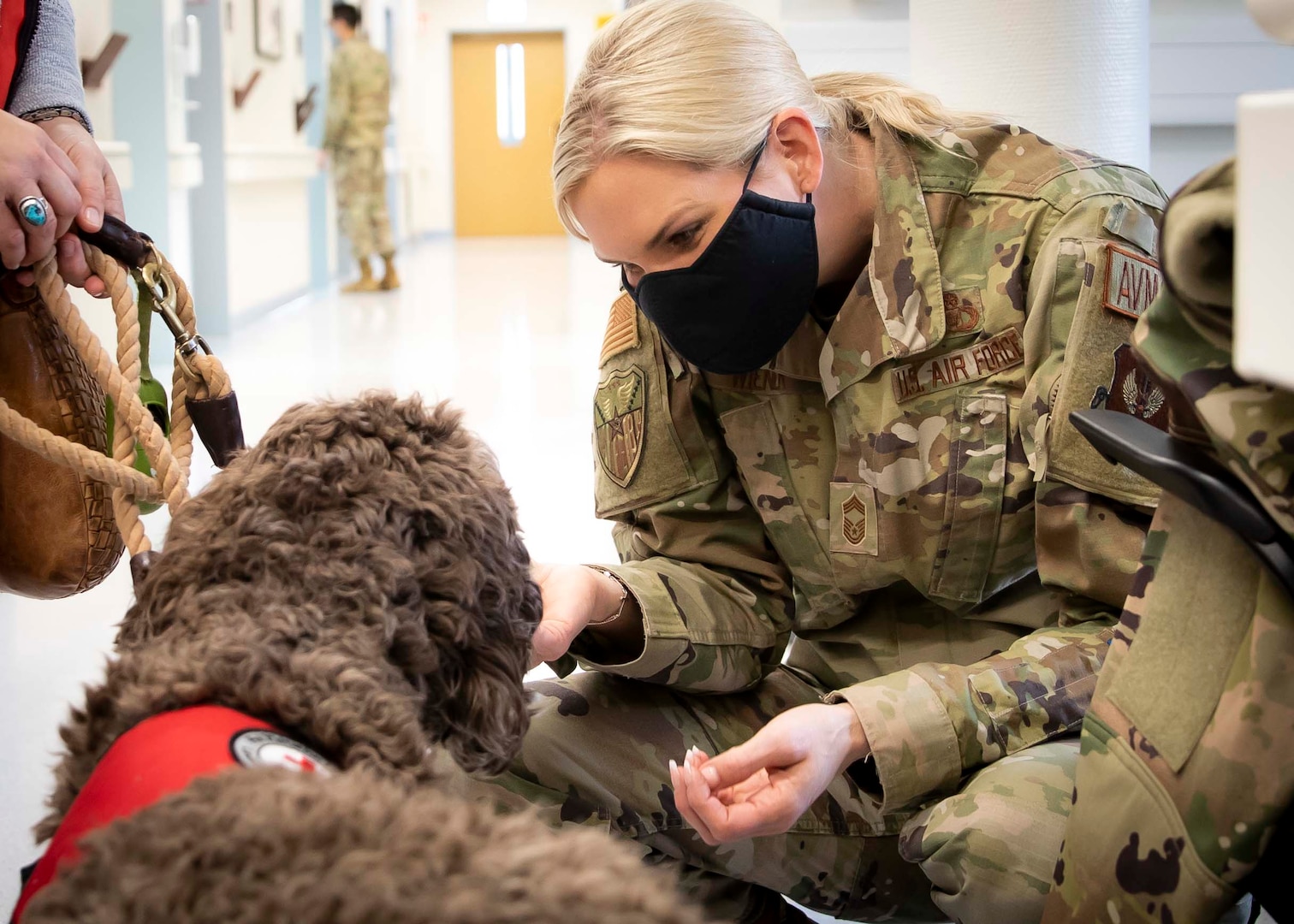 Chief Master Sgt. Kristy Wiener, Major Command functional manager, Aviation Resource Management, U.S. Air Forces in Europe and Air Forces Africa, is greeted by Saif, an American Red Cross volunteer, during his first day volunteering with the Landstuhl American Red Cross Pet Visitation Program, at Landstuhl Regional Medical Center, Jan. 19.