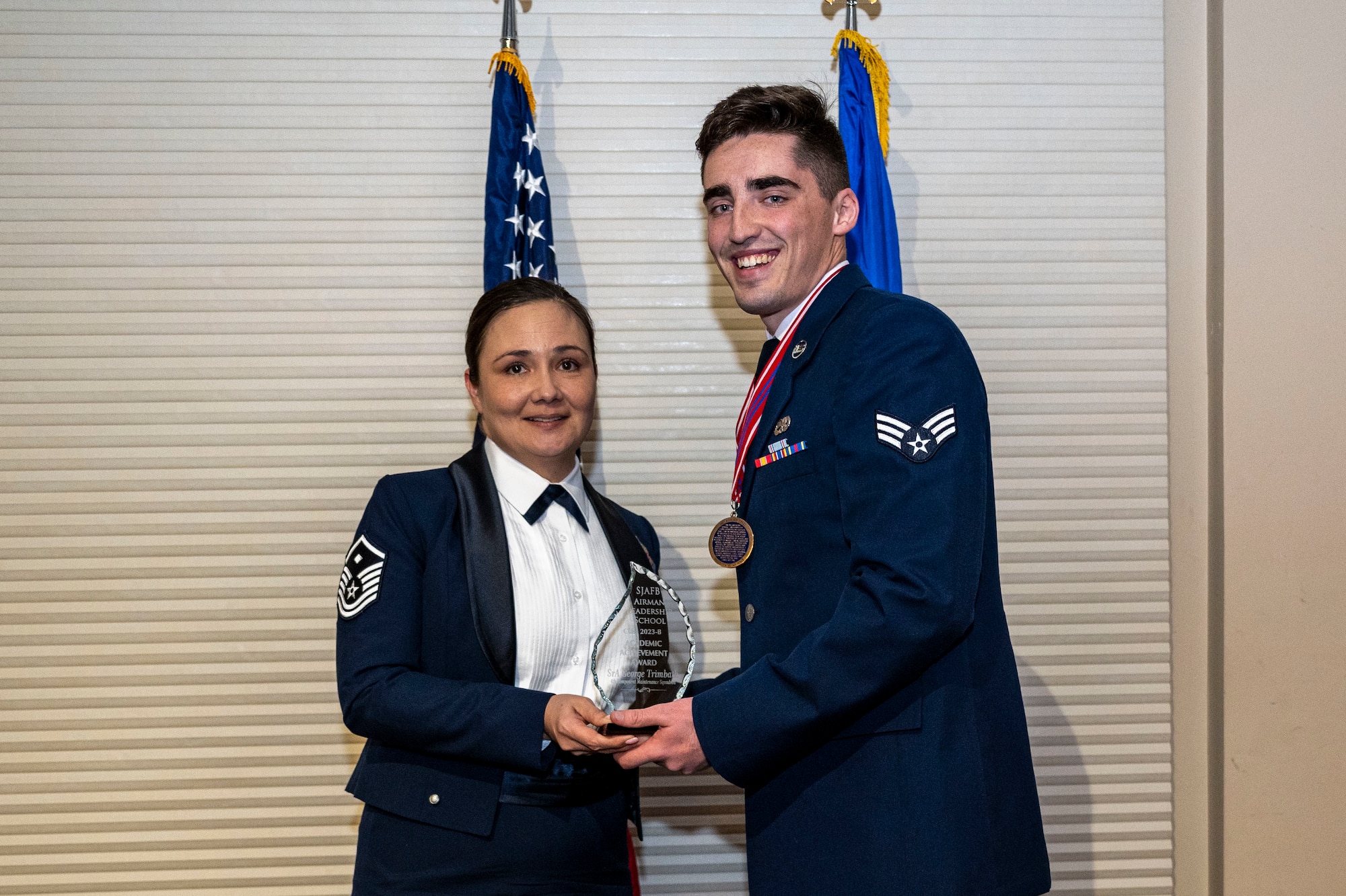 Senior Airman George Trimbath, 4th Component Maintenance Squadron electronics technician, right, receives the academic achievement award from Master Sgt. Suge Wilson, 4th Medical Group first sergeant, during Airman Leadership School class 23-B graduation at Seymour Johnson Air Force Base, North Carolina, Feb. 9, 2023. The academic achievement award was given to the Airman who achieved the highest academic average throughout the course.