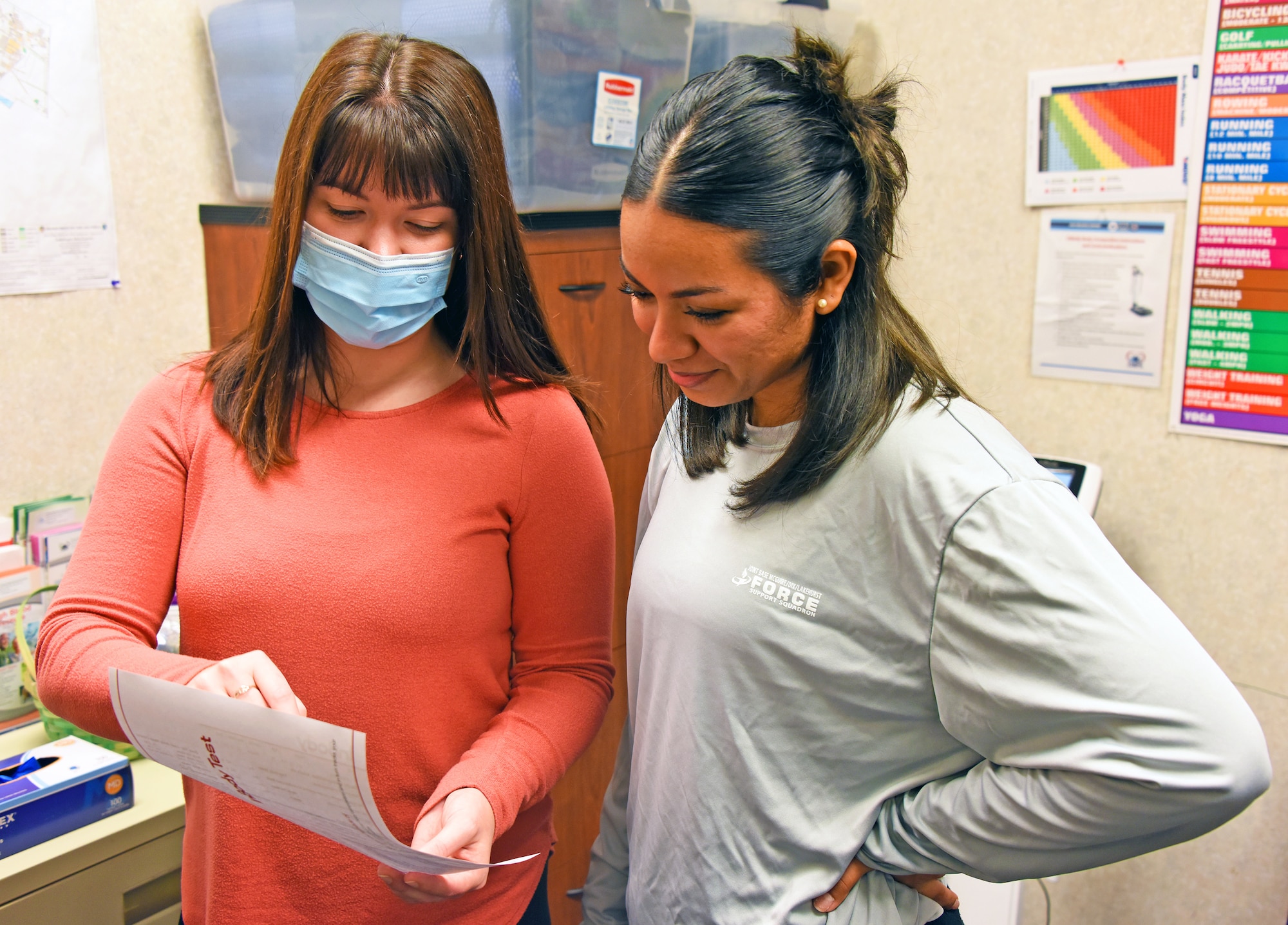 A CHPS health promotion coordinator shows health records to an Airman.