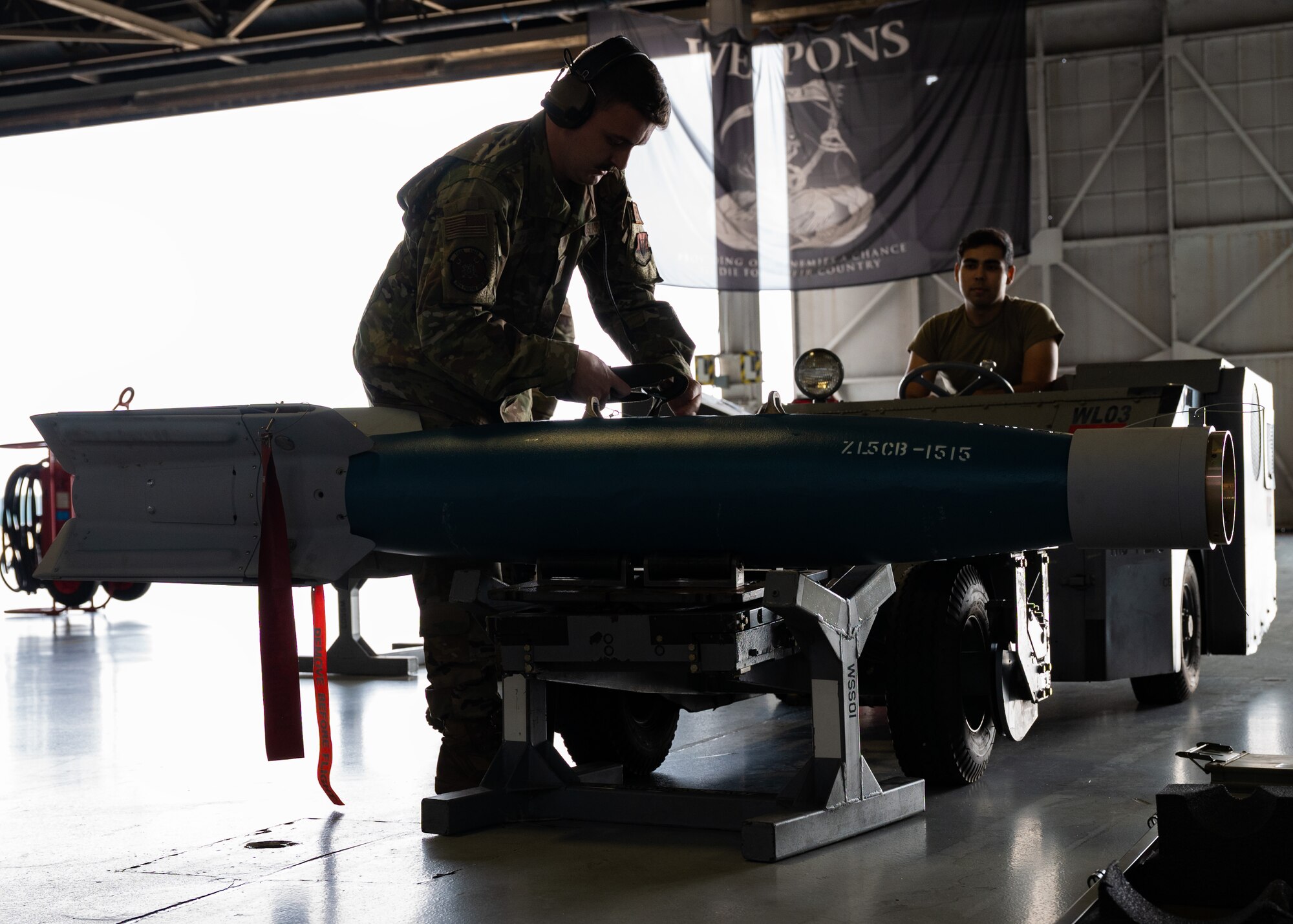 U.S. Air Force Staff Sgt. secures munition to an MJ-1 standard lift truck