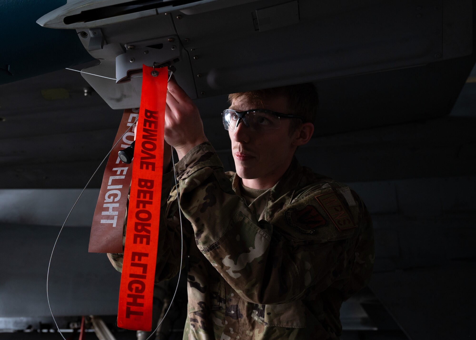 U.S. Air Force Senior Airman secures a wire to an F-16C Fighting Falcon