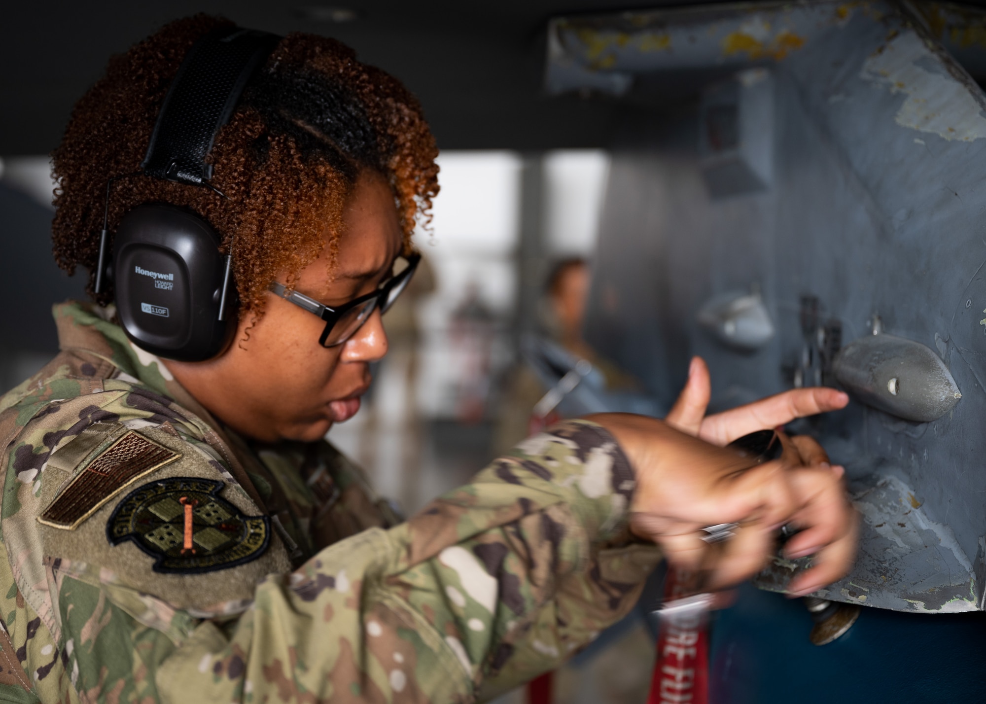U.S. Air Force Senior Airman screws bolt onto an F-16C Fighting Falcon