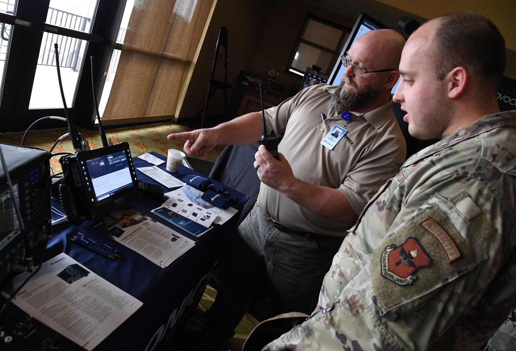 Dan Robinett, Astronics Test Systems product specialist, provides an equipment overview to U.S. Air Force Tech. Sgt. Jessie Ludlum, 333rd Training Squadron instructor, during the Technology Expo inside the Bay Breeze Event Center at Keesler Air Force Base, Mississippi, Feb. 16, 2023.