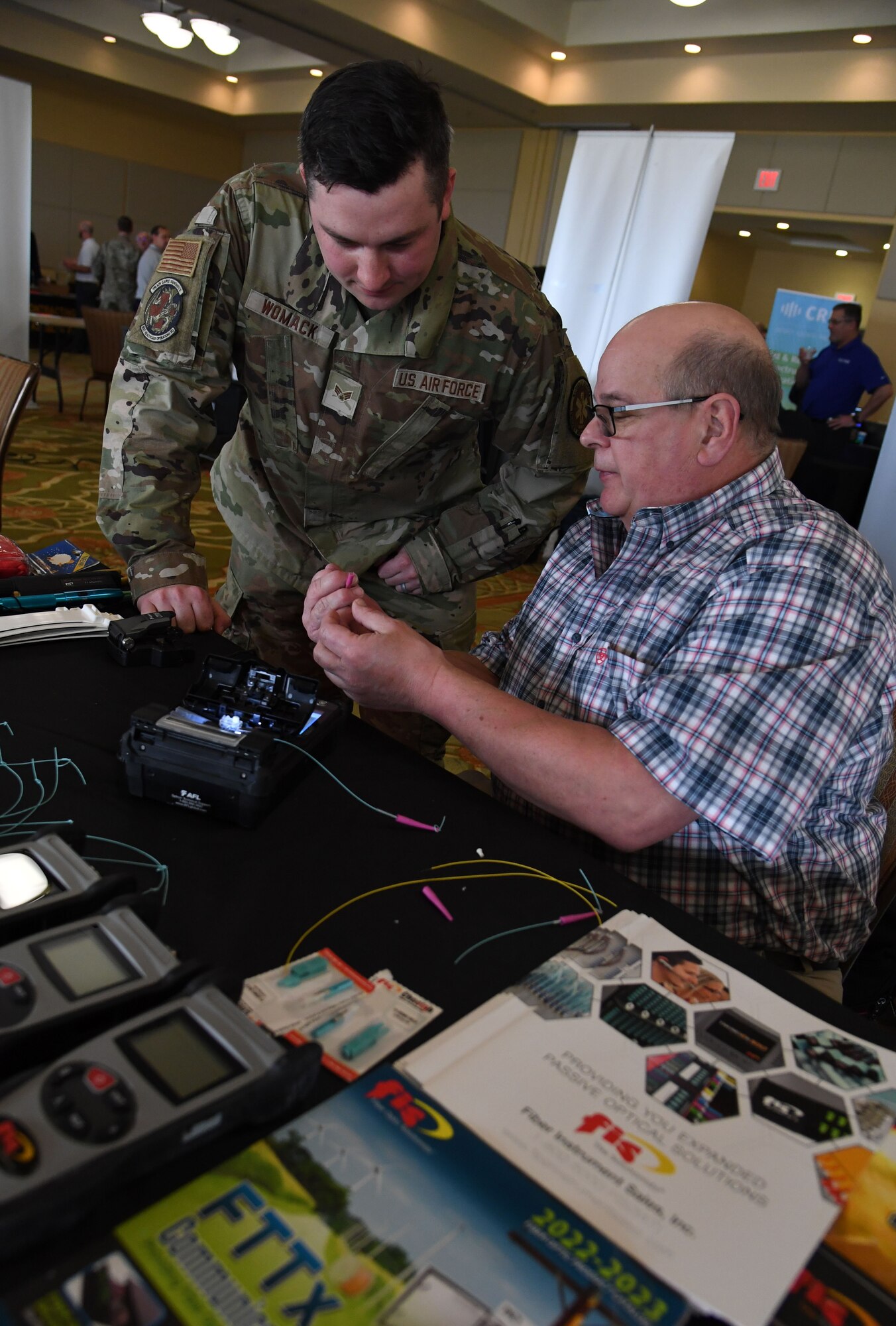 John DeMetro, Fis corporate accounts manager, provides an equipment overview to U.S. Air Force Senior Airman Taylor Womack, 81st Healthcare Operations Squadron medical technician, during the Technology Expo inside the Bay Breeze Event Center at Keesler Air Force Base, Mississippi, Feb. 16, 2023.