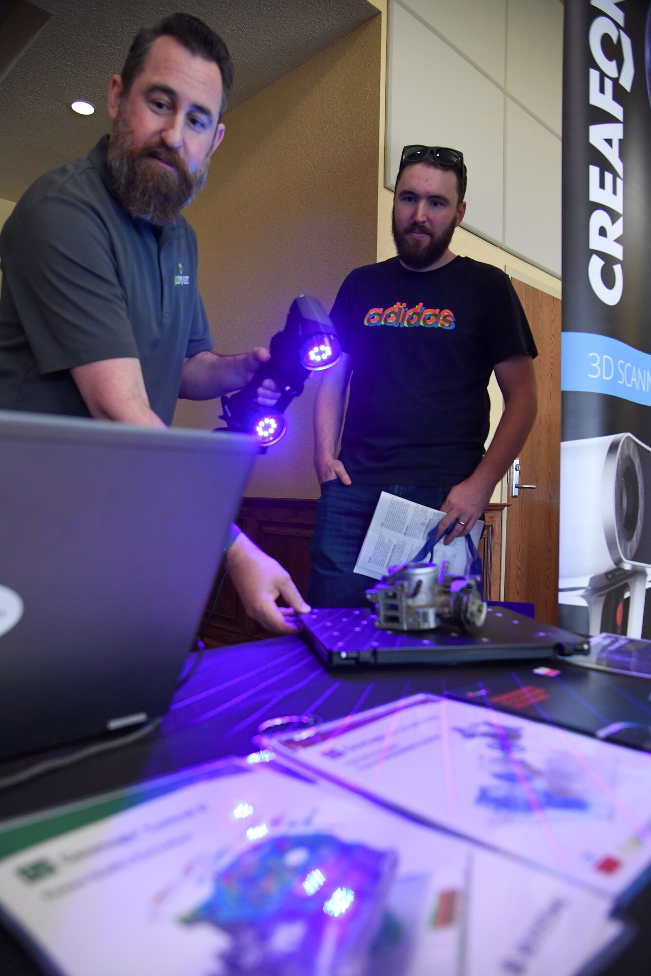 Andy Grayson, Goengineer territory sales manager, conducts an equipment demonstration for Nathaniel Schaaf, spouse of U.S. Air Force Maj. Andrea Schaaf, 81st Communications Squadron commander, during the Technology Expo inside the Bay Breeze Event Center at Keesler Air Force Base, Mississippi, Feb. 16, 2023.