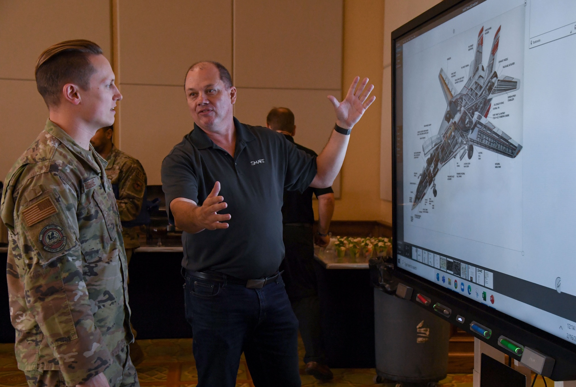 Rick English, Smart technologies channel manager, provides an equipment overview to U.S. Air Force Tech. Sgt. Russell Osborne, 81st Operations Support Flight air traffic control watch supervisor, during the Technology Expo inside the Bay Breeze Event Center at Keesler Air Force Base, Mississippi, Feb. 16, 2023.