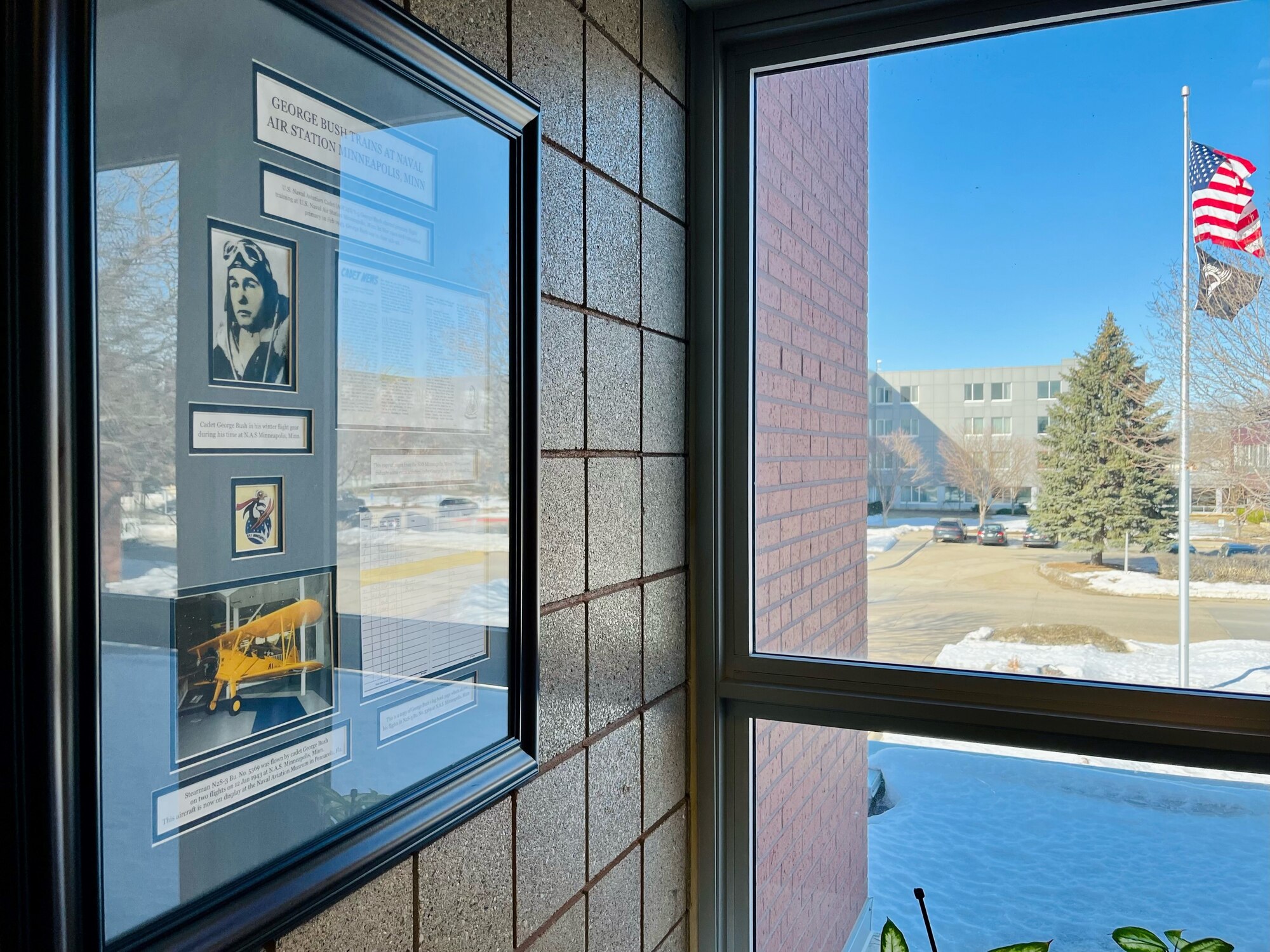 The wooden frame highlighting then Cadet George Bush hangs outside of the command suite of the 934th Airlift Wing front office overlooking the wing's flagpole. (Photo by Master Sgt. Trevor Saylor).