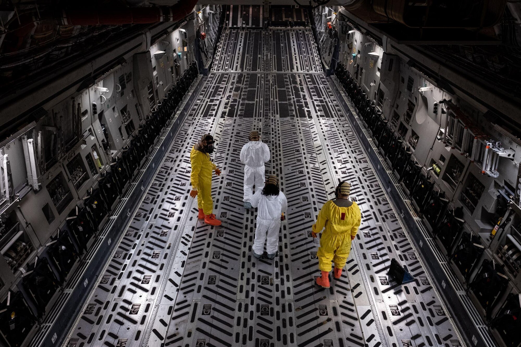 4 people walk down cargo bay