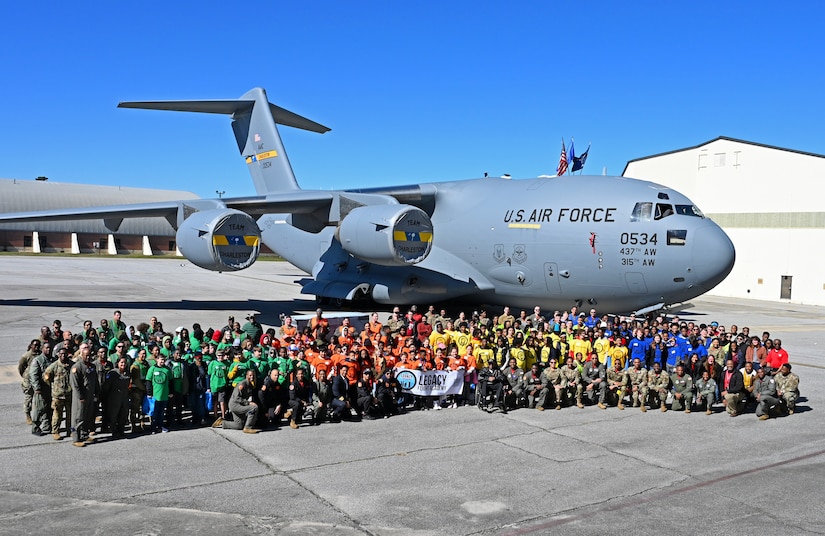 A photo of more that 200 students and volunteers next to a jet.