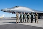 A photo of five people standing in front of a jet.